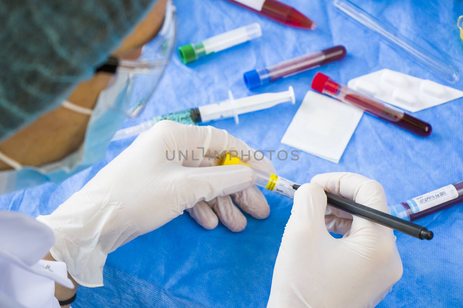 Doctor in laboratory with uniform write text on the blood tube sample, white glove