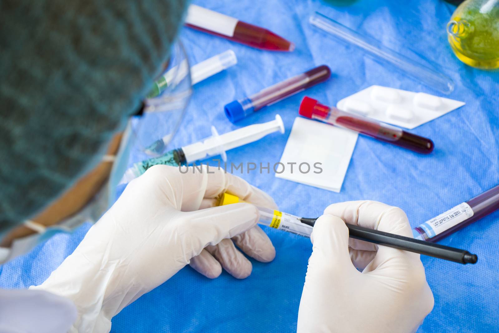 Doctor in laboratory with uniform write text on the blood tube sample, white glove