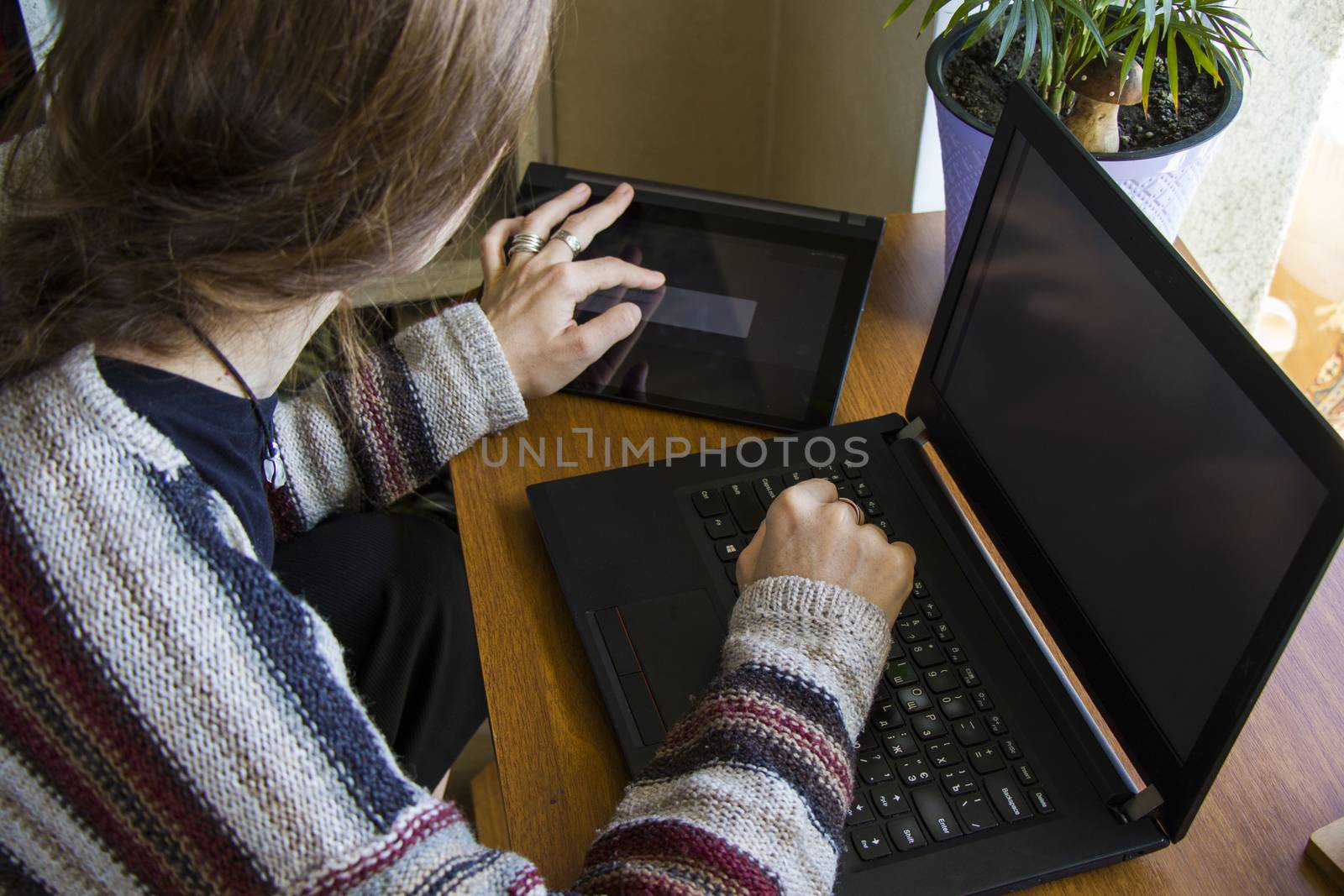 Woman working with notebook in workplace, digital tablet, mobile phone, coffee and plants in workspace, home working