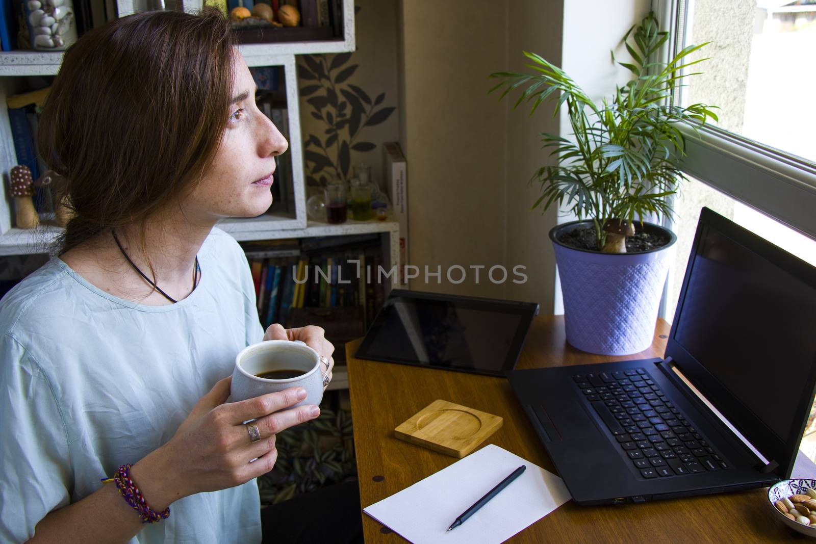 Woman working in office with digital tablet and notebook by Taidundua