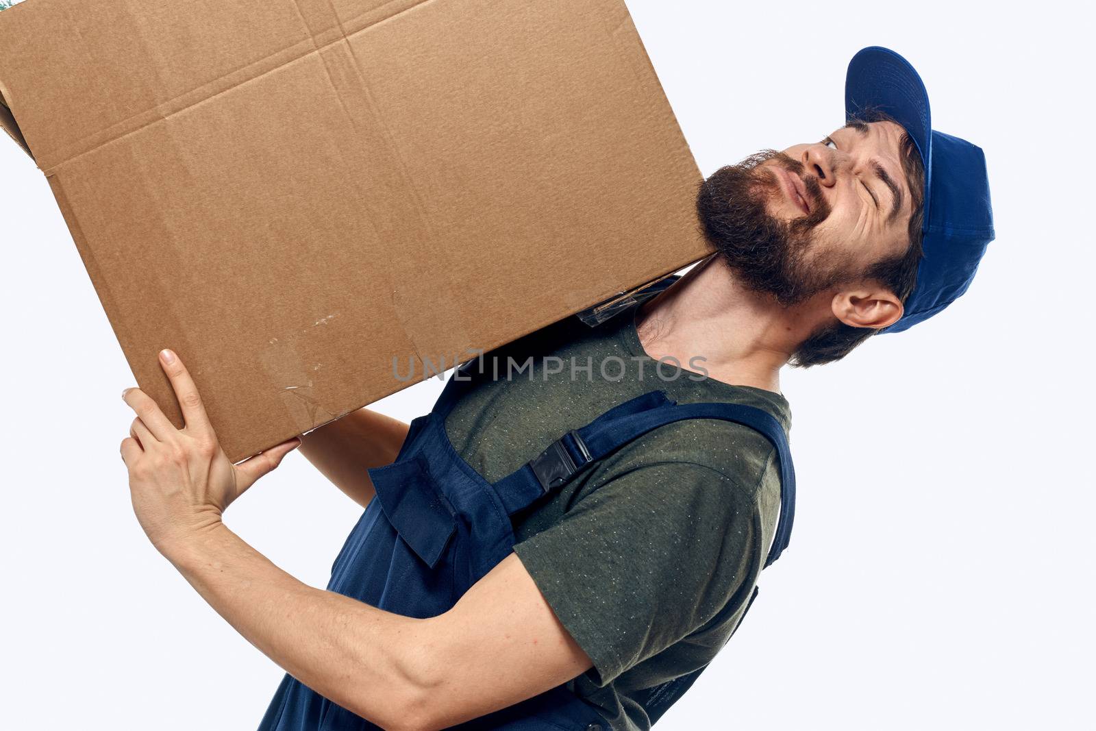 A man in a working uniform with a box in his hands delivery transportation work. High quality photo