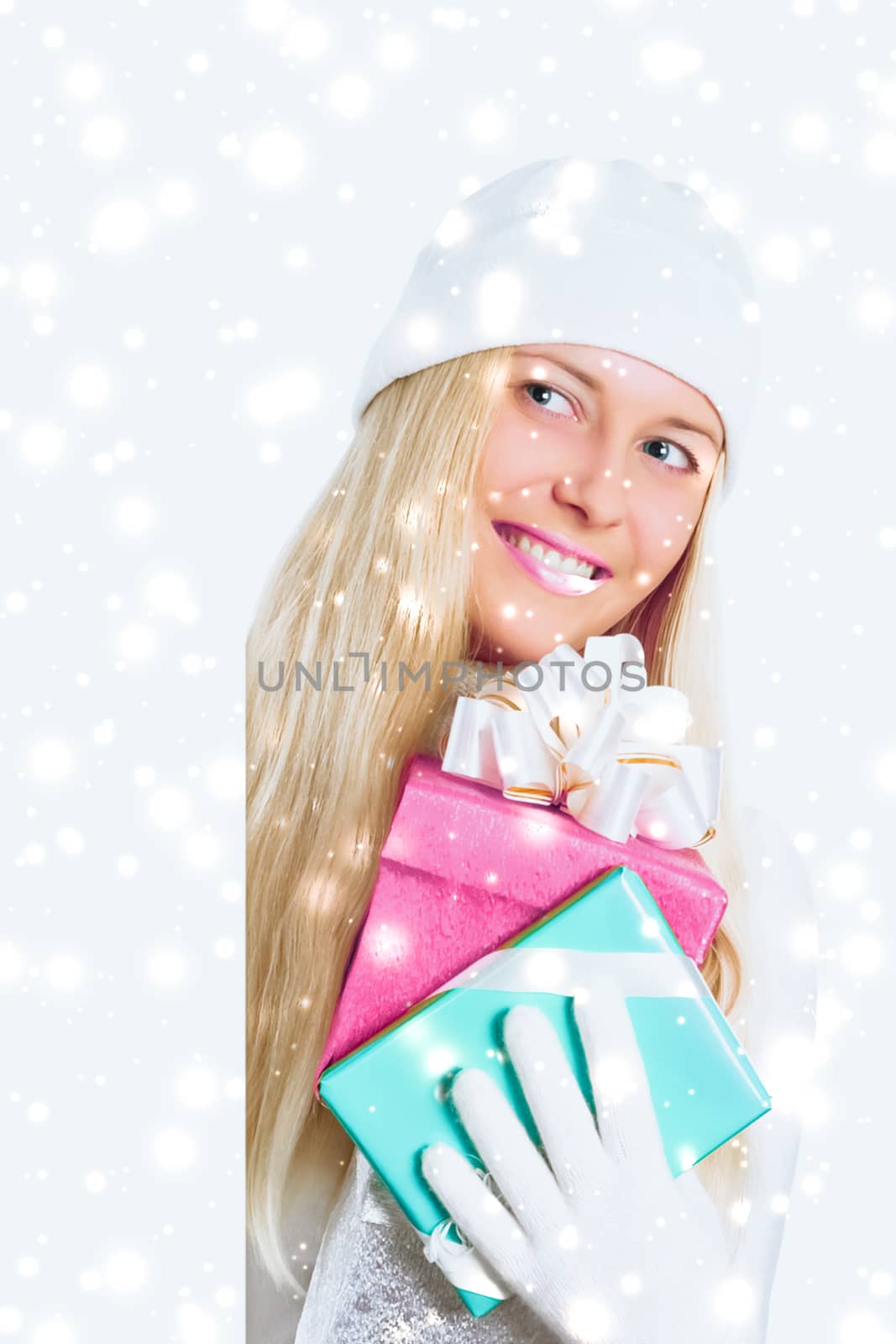 Happy woman holding Christmas gifts, silver background and snow glitter with copyspace, shopping and holidays
