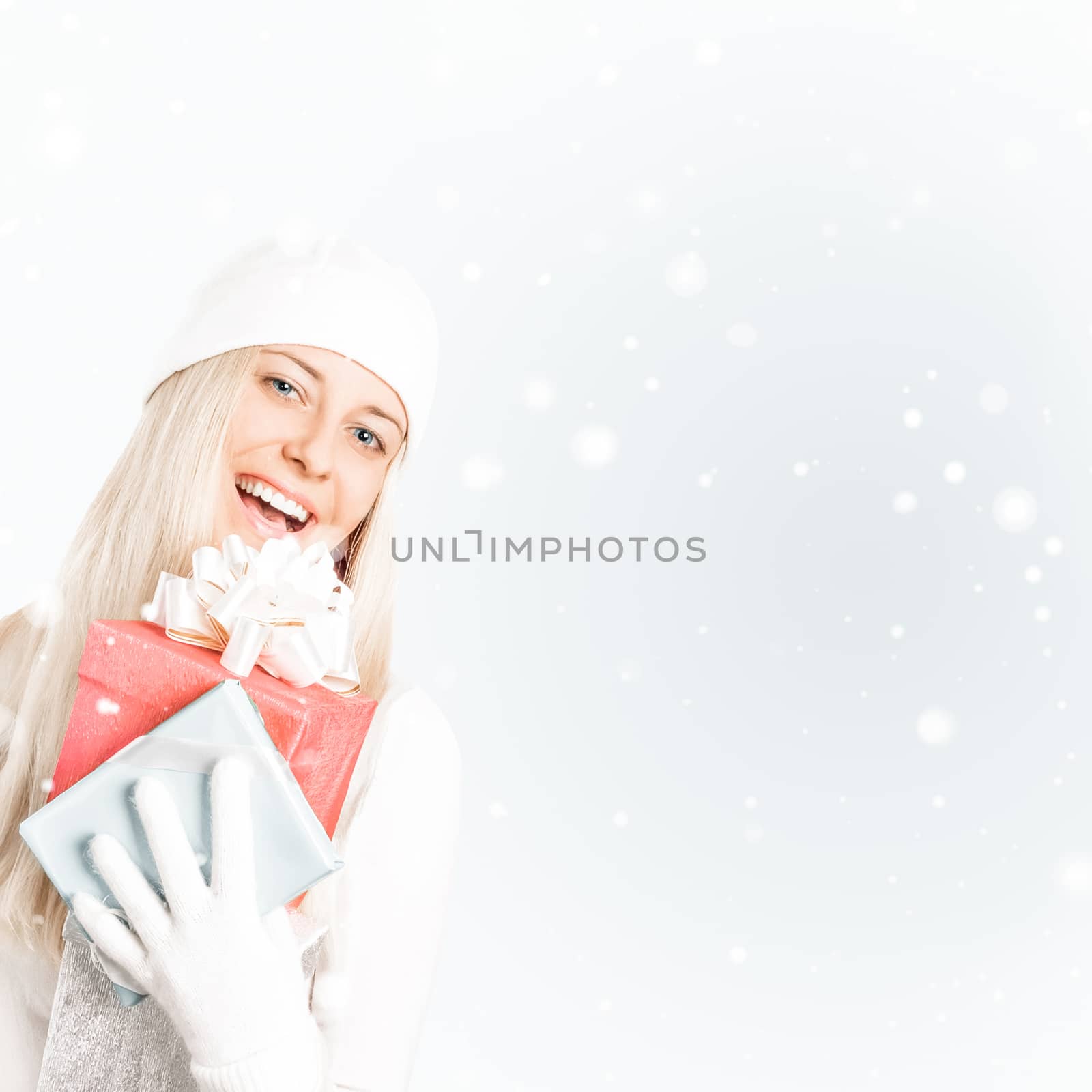 Happy woman holding Christmas gifts, silver background and snow glitter with copyspace, shopping and holidays