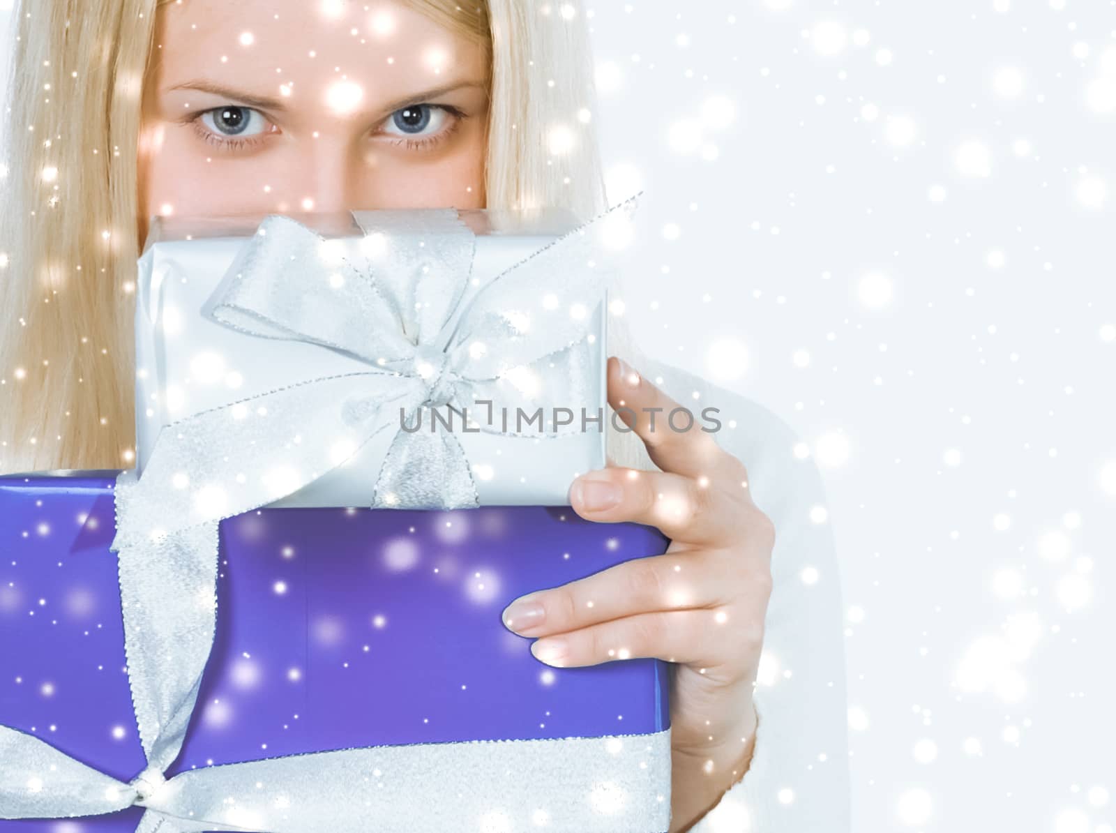 Happy woman holding Christmas gifts, silver background and snow glitter with copyspace, shopping and holidays