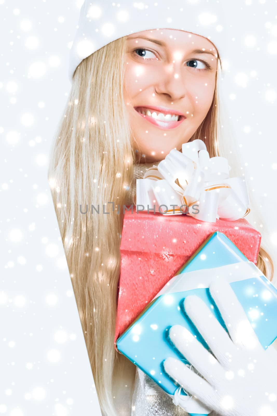 Happy woman holding Christmas gifts, silver background and snow glitter with copyspace, shopping and holidays