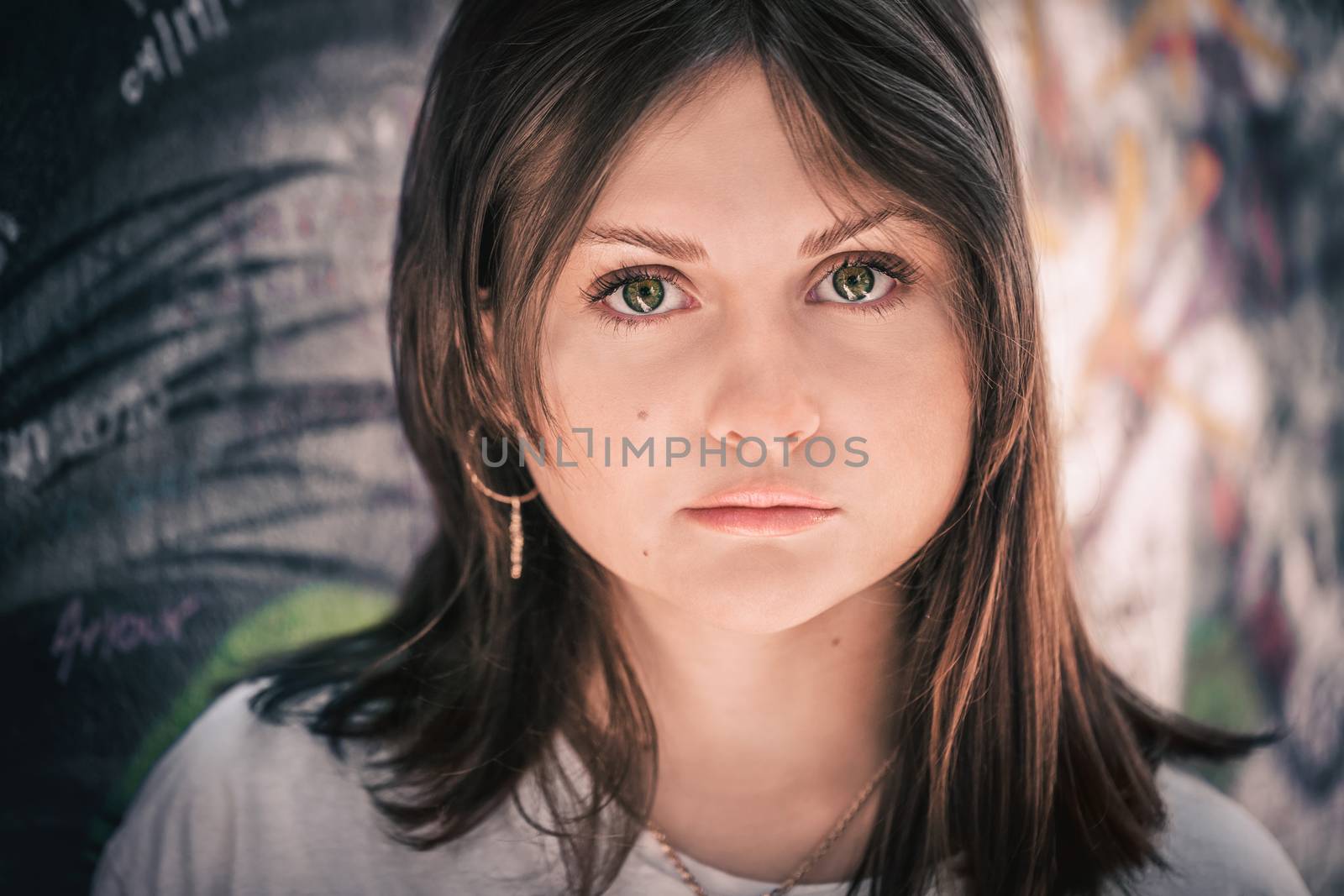 Profile portrait of a teenage girl with long hair on a wall background