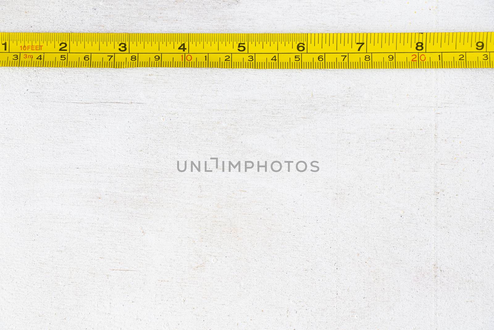 Metal ruler, centimeters and millimeters on the yellow ruler. Sizes on the white background