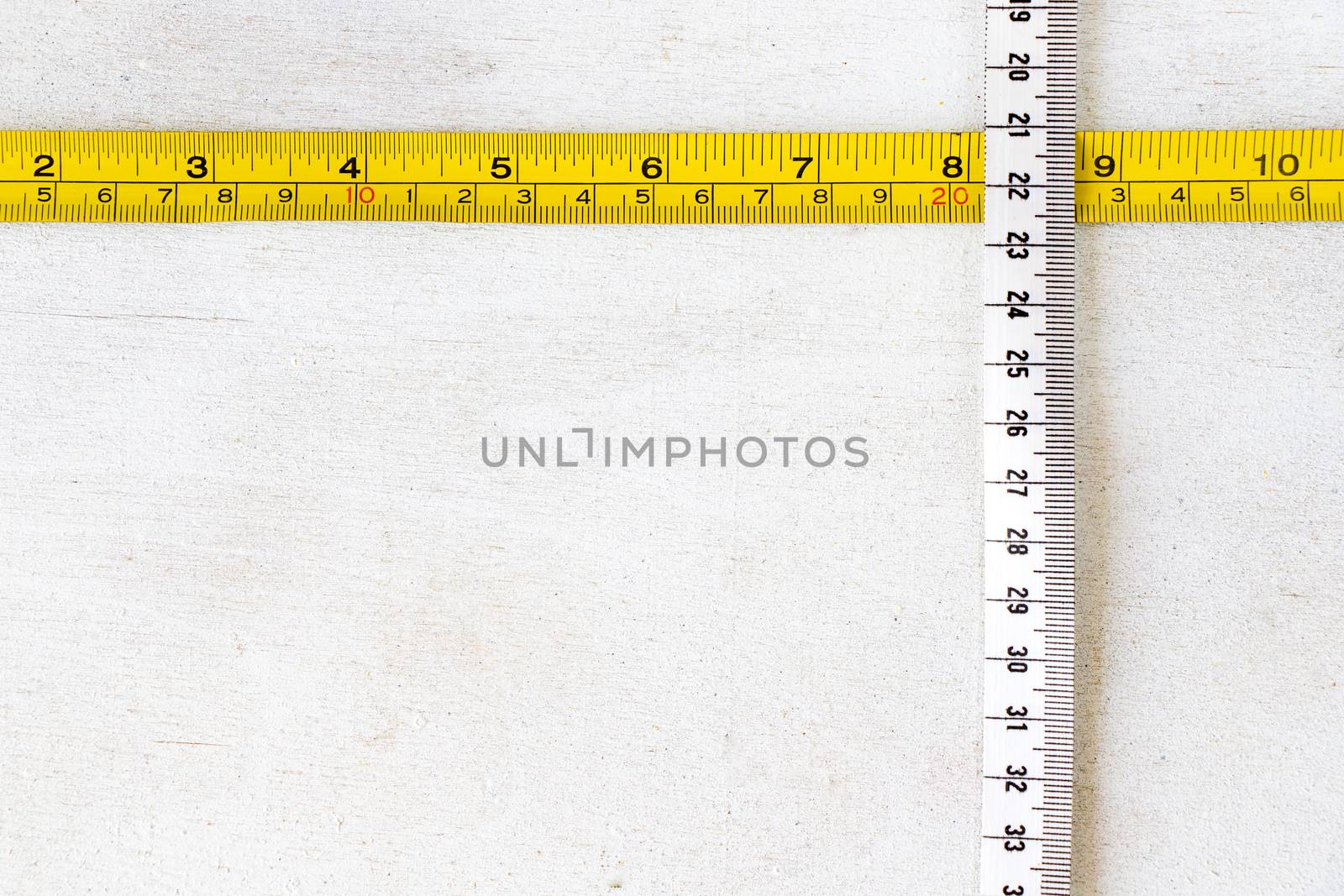 Metal ruler and Tape measure, centimeters and millimeters on the yellow ruler. Sizes on the white background