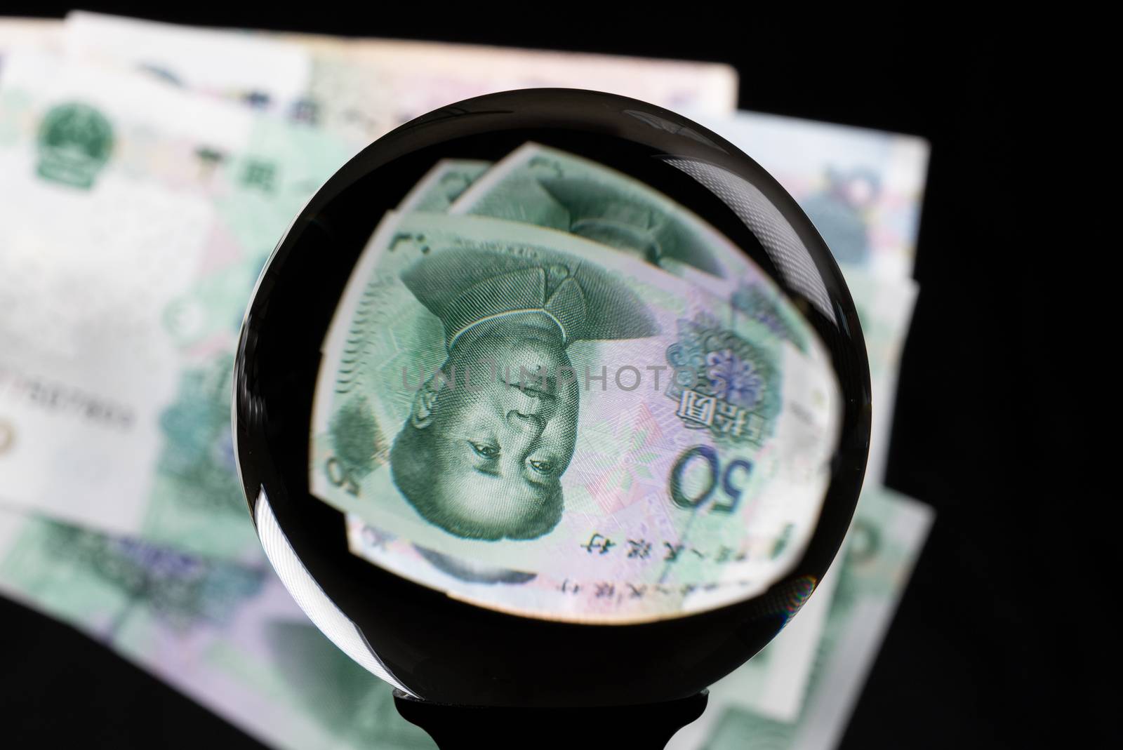 Crystal futures or fortune telling ball reflecting a China 50 Yuan note as concept for the exchange rate for the currency