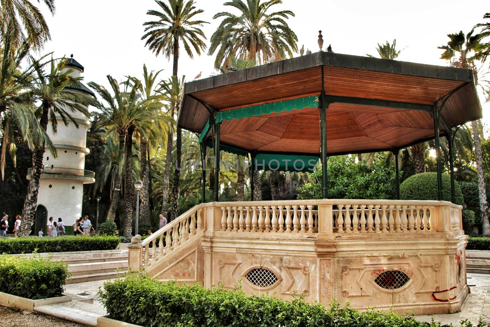 Elche, Alicante, Spain- September 16, 2018: Beautiful and vintage music kiosk in the municipal park of Elche between palm trees. Elche, Alicante, Spain.