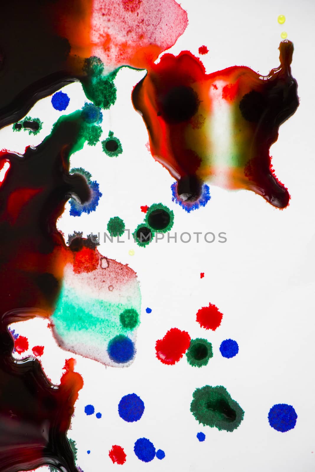 Ink drops on the paper, red, green and blue ink splashes background, painting and drawing