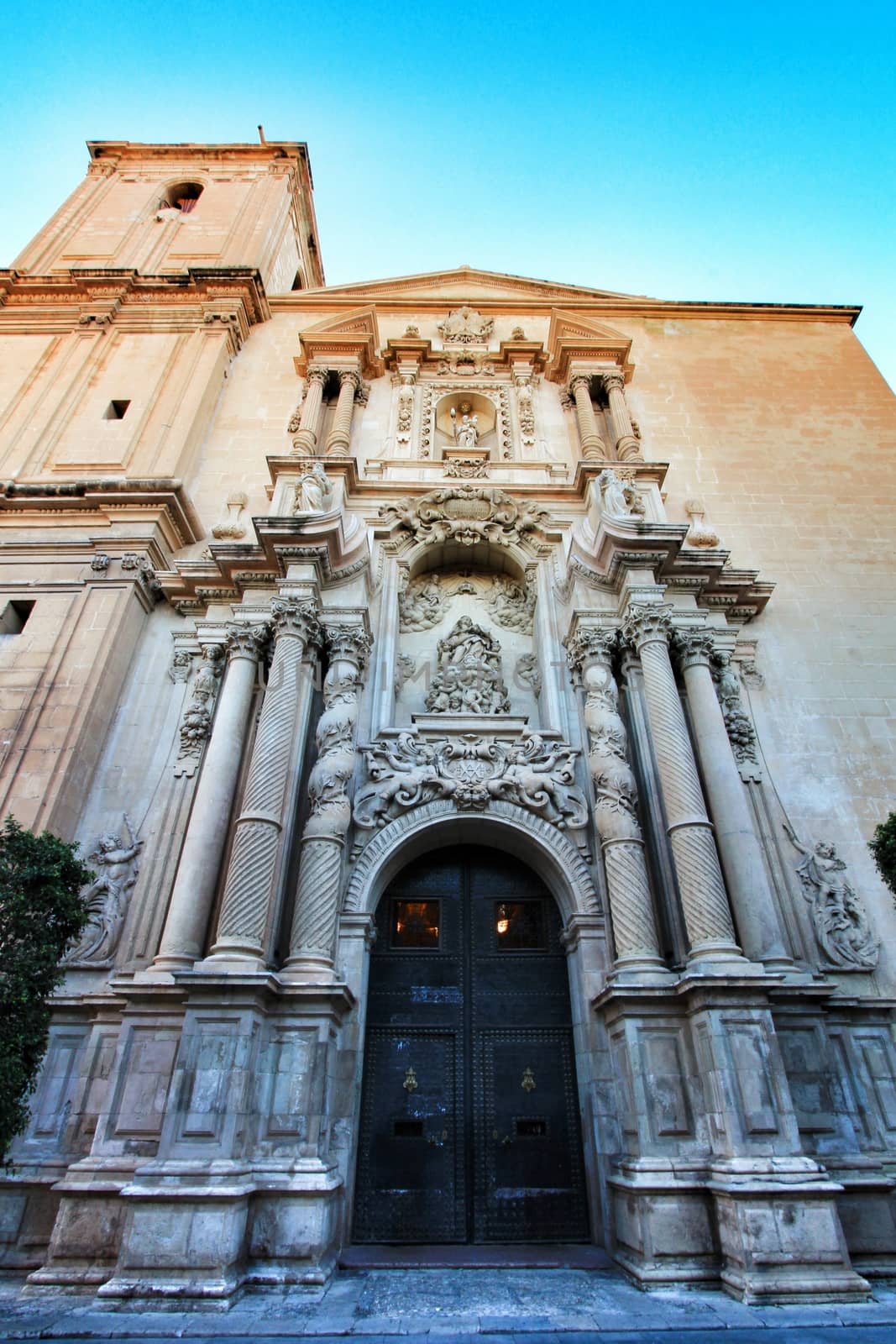 Elche, Alicante, Spain- September 9, 2020: Main entrance and beautiful Valencian baroque facade of Santa Maria church dedicated to the Lady of the Assumption
