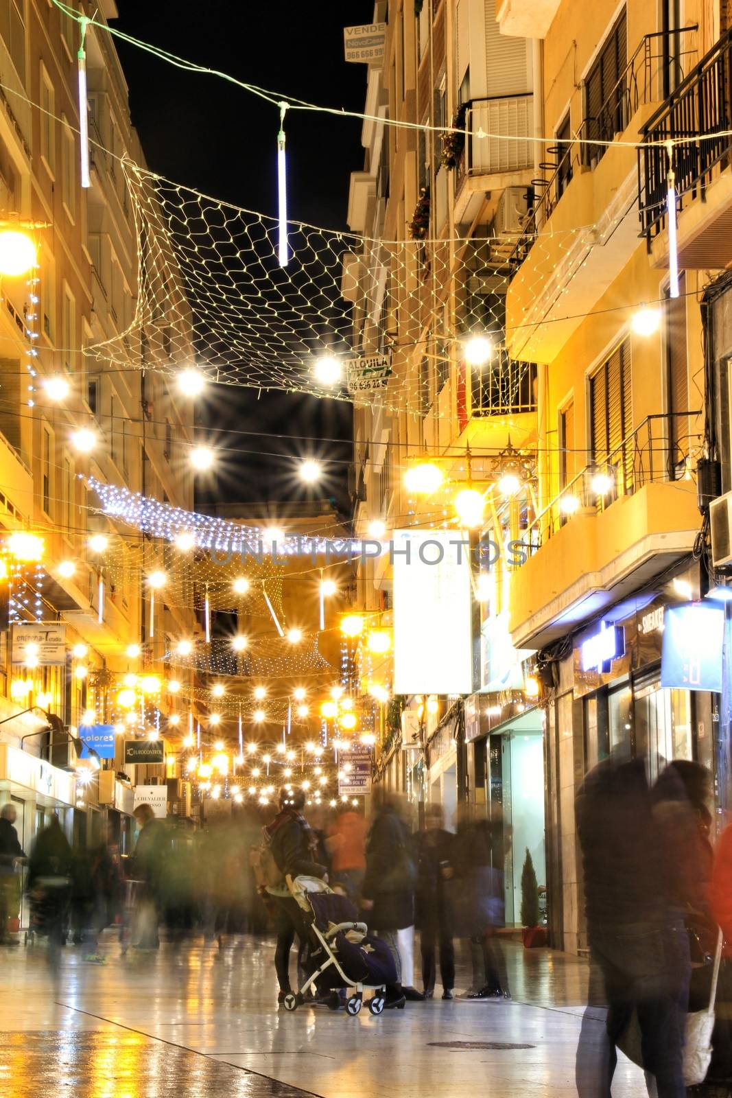 Elche, Alicante, Spain- December 11, 2019: People enjoying and walking at night through the beautiful streets of Elche decorated with lighting and Christmas motifs