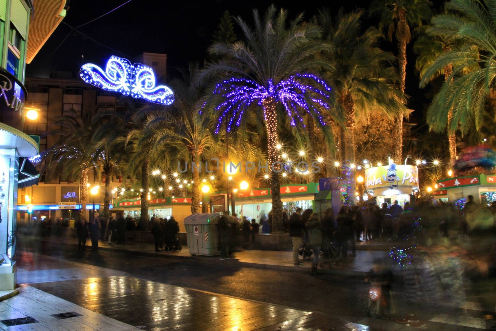 Elche, Alicante, Spain- December 11, 2019: People enjoying and walking at night through the beautiful streets of Elche decorated with lighting and Christmas motifs
