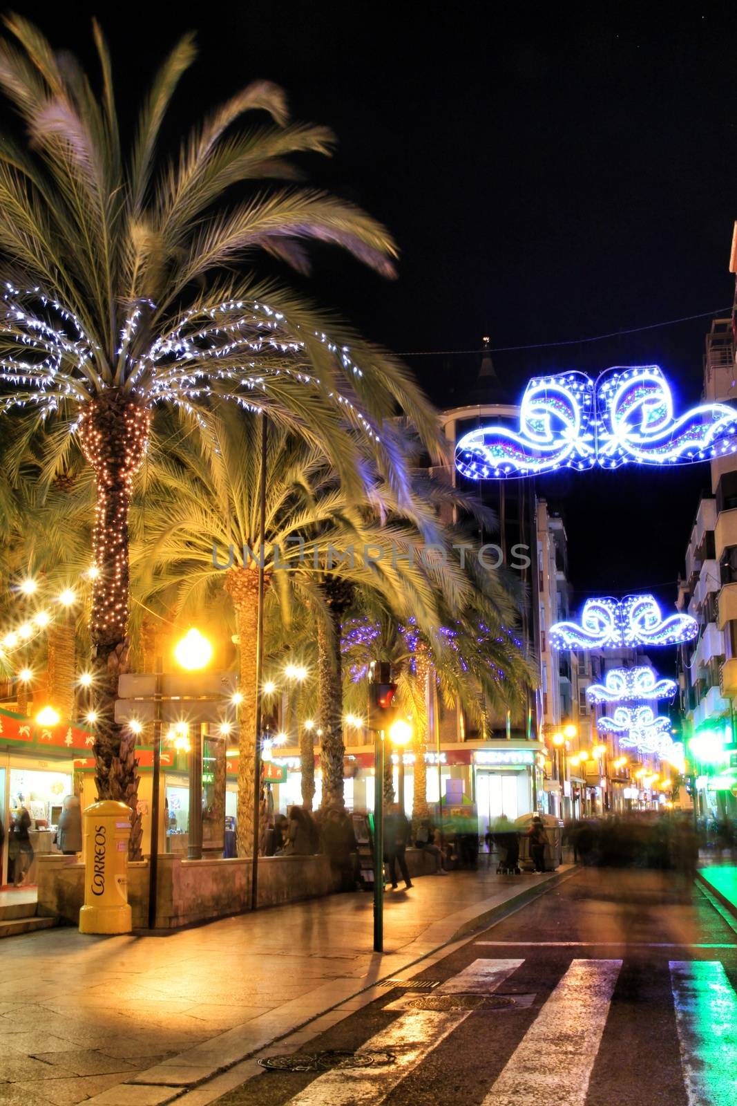 Elche, Alicante, Spain- December 11, 2019: People enjoying and walking at night through the beautiful streets of Elche decorated with lighting and Christmas motifs
