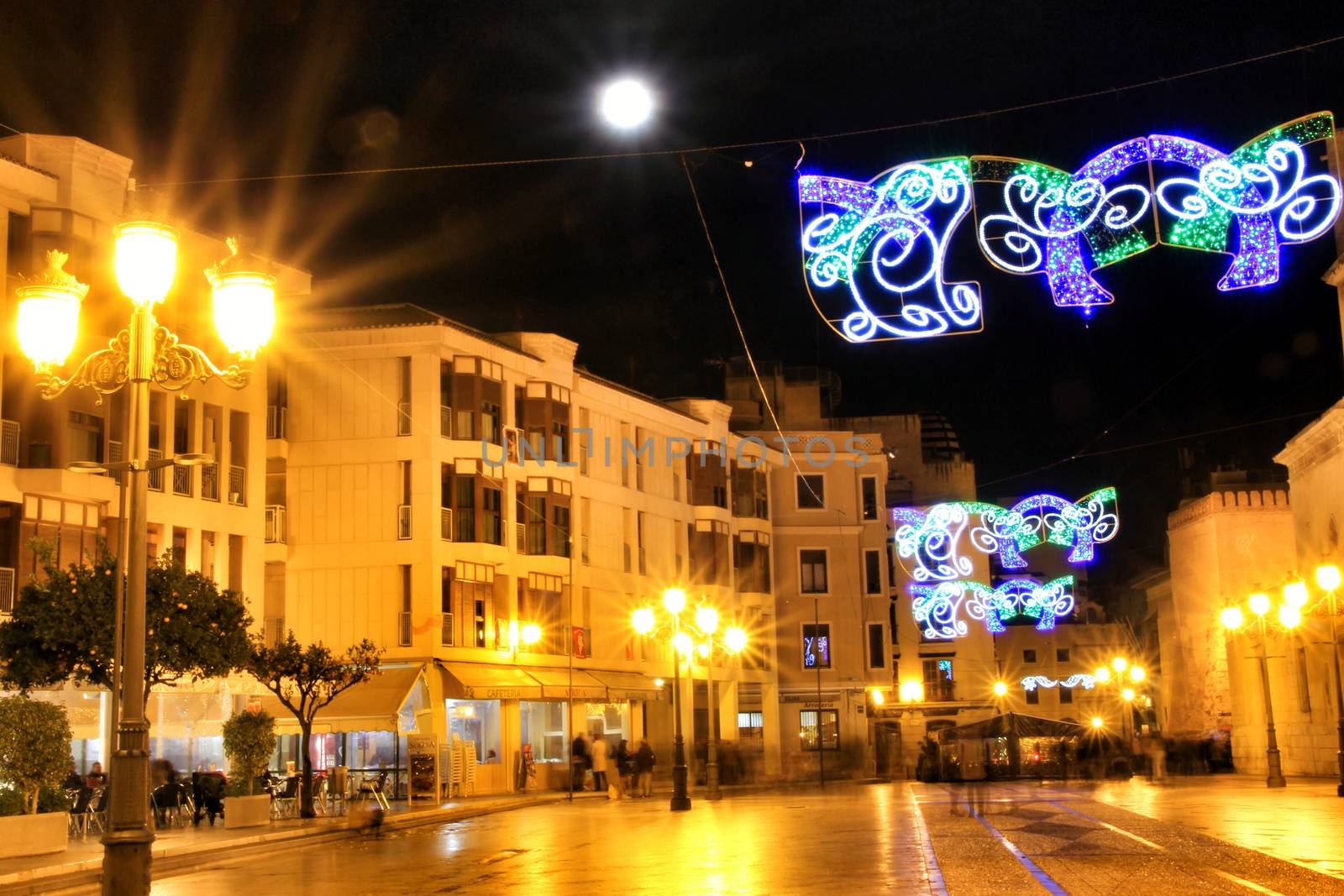 Elche, Alicante, Spain- December 11, 2019: People enjoying and walking at night through the beautiful streets of Elche decorated with lighting and Christmas motifs