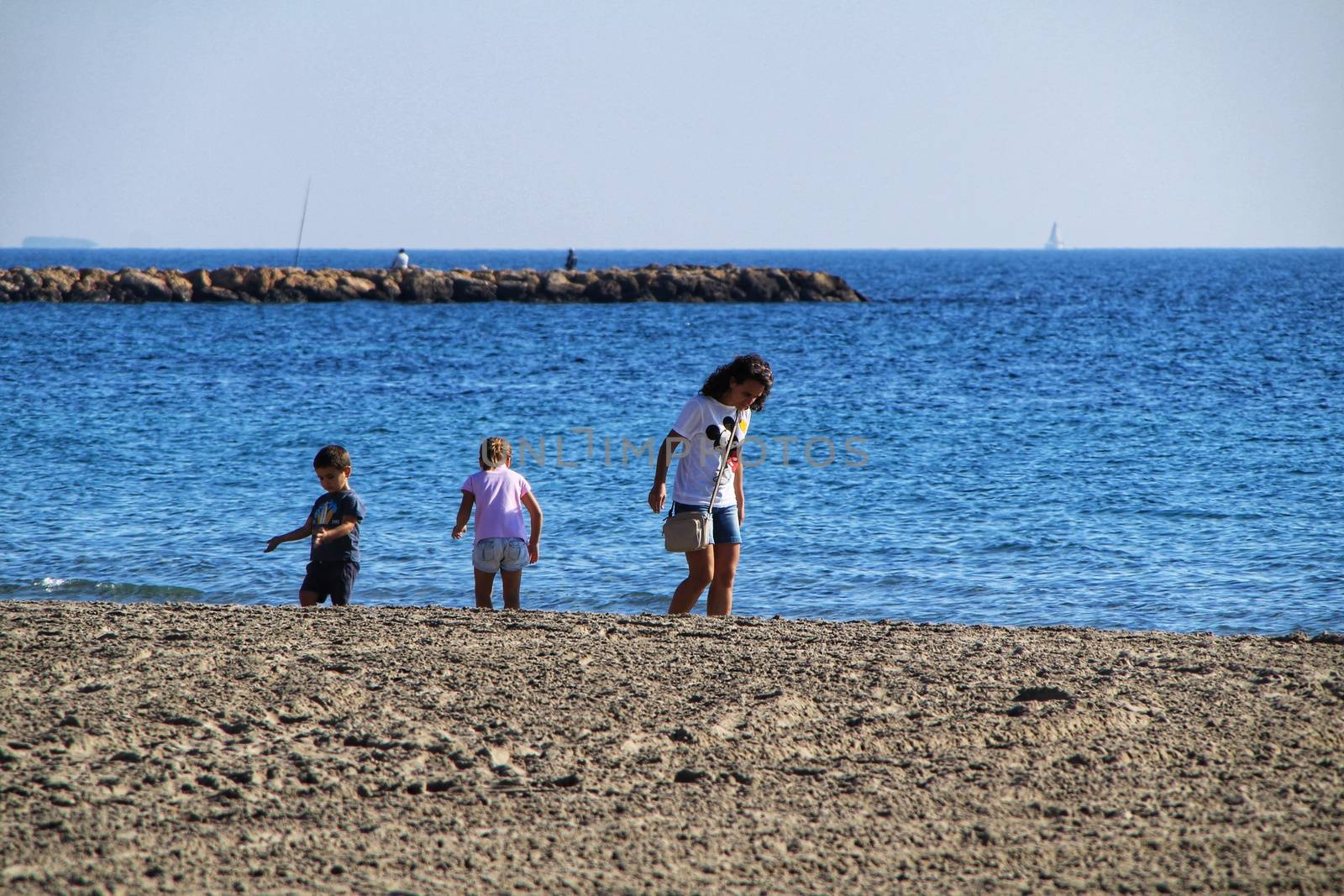Santa Pola, Alicante, Spain- December 6, 2018: People enjoying and relaxing a sunny day of winter on the beach in Santa Pola, Spain.