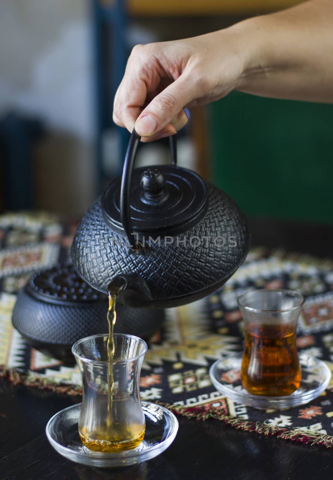 Black tea and teapot in hand, Turkish tea glasses by Taidundua