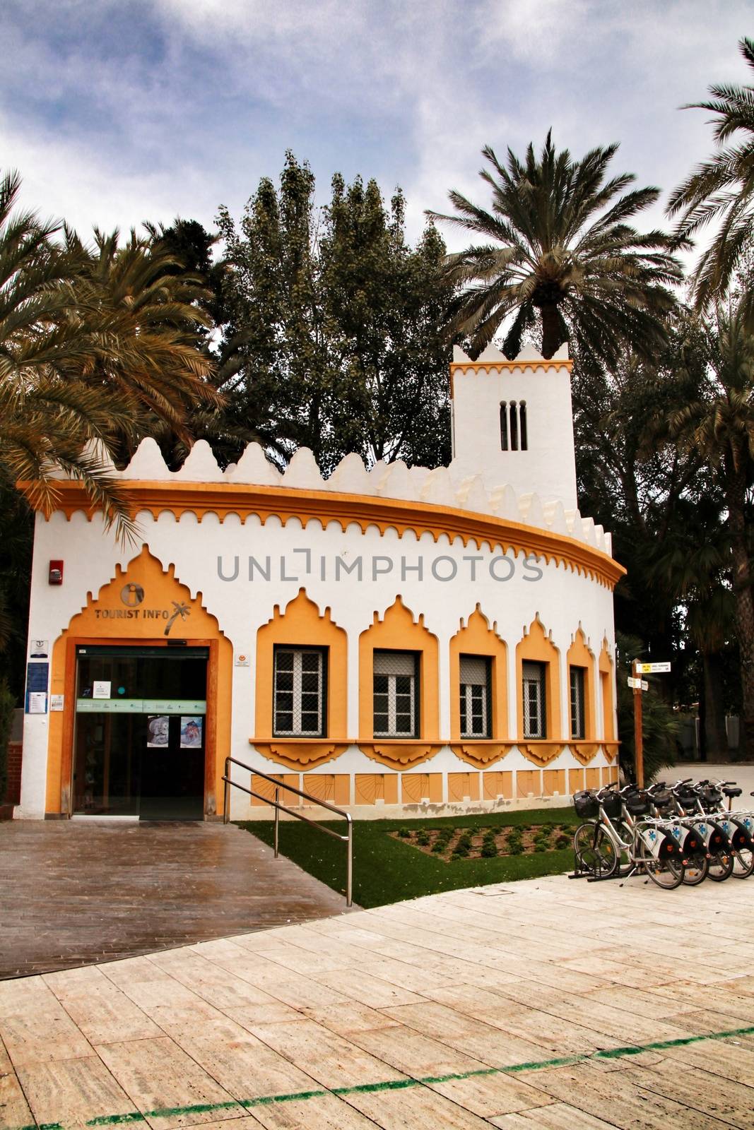 Elche, Alicante, Spain- February 19, 2019: Tourist Office surrounded by palm trees in the municipal park of Elche, Alicante province, Spain