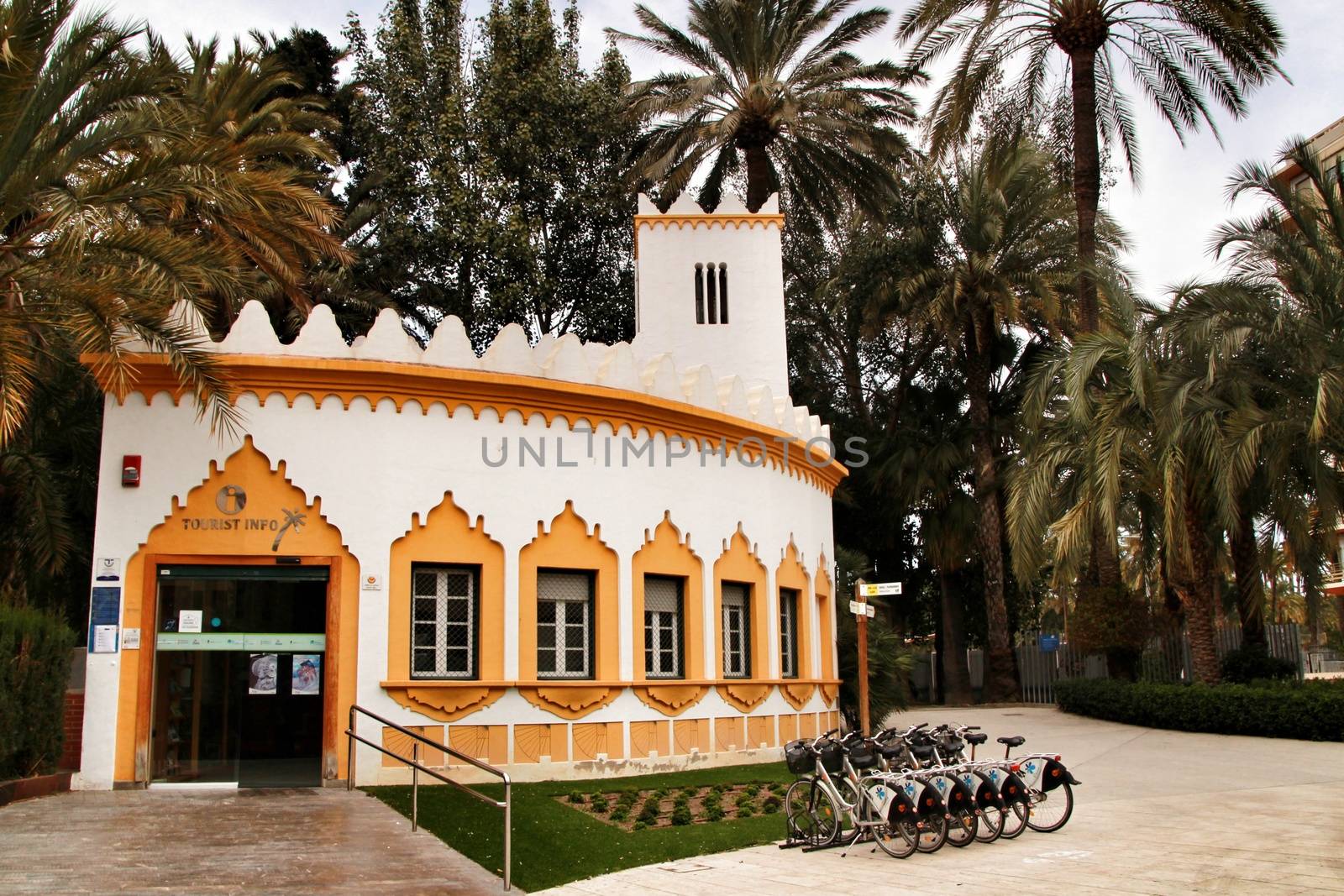 Elche, Alicante, Spain- February 19, 2019: Tourist Office surrounded by palm trees in the municipal park of Elche, Alicante province, Spain