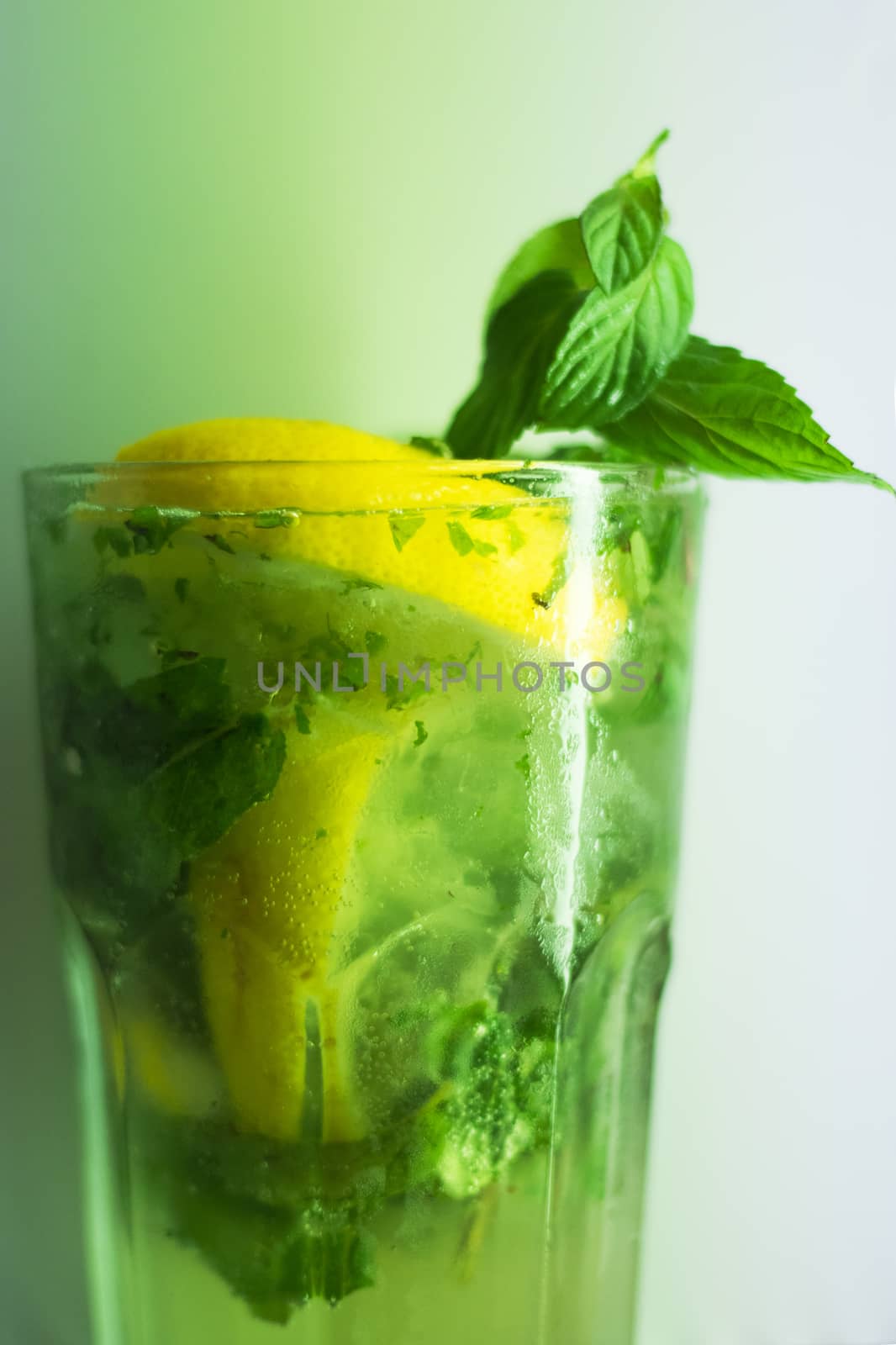 Mojito cocktail in glass,fresh drink, ready to drink, mint, lemon and lime with alcohol and ice cubes. Green color. white background.