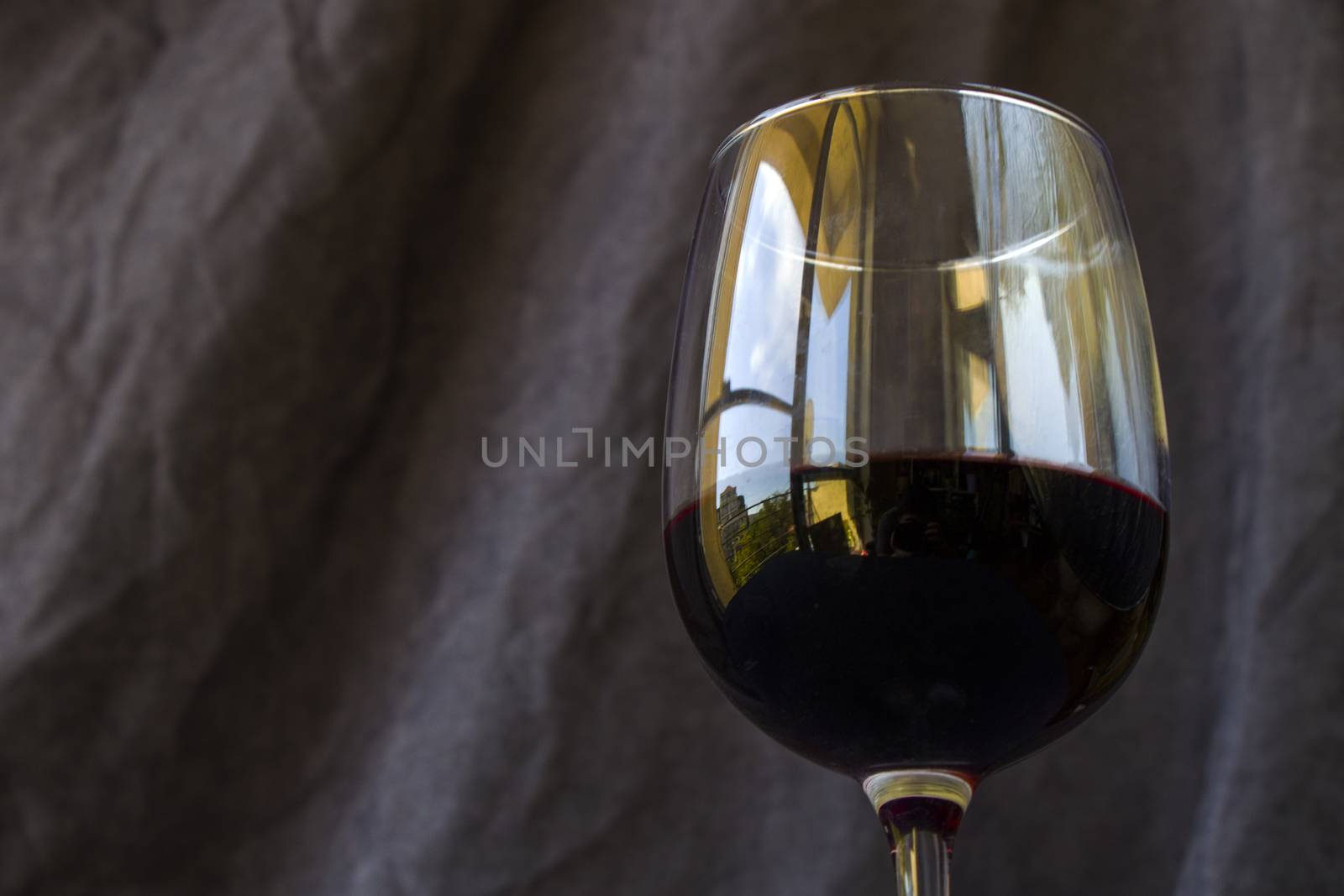 Full red wine glass on the dark and gray background by Taidundua