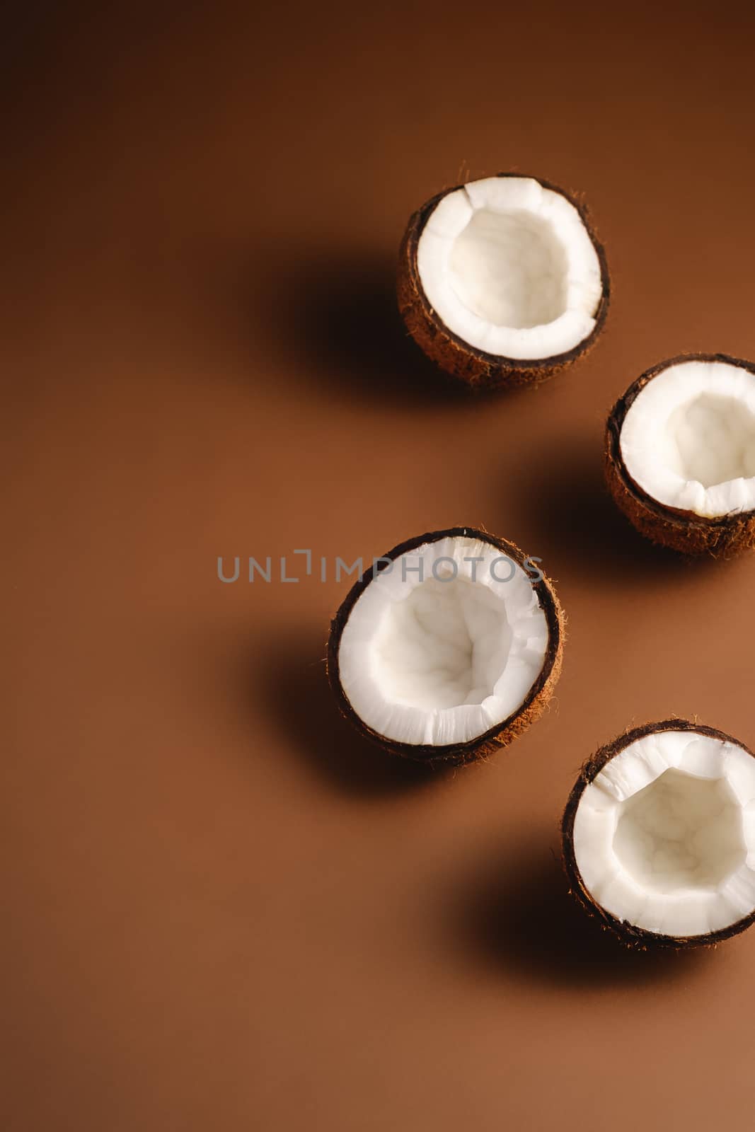 Coconut fruits on brown plain background, abstract food tropical concept, angle view copy space