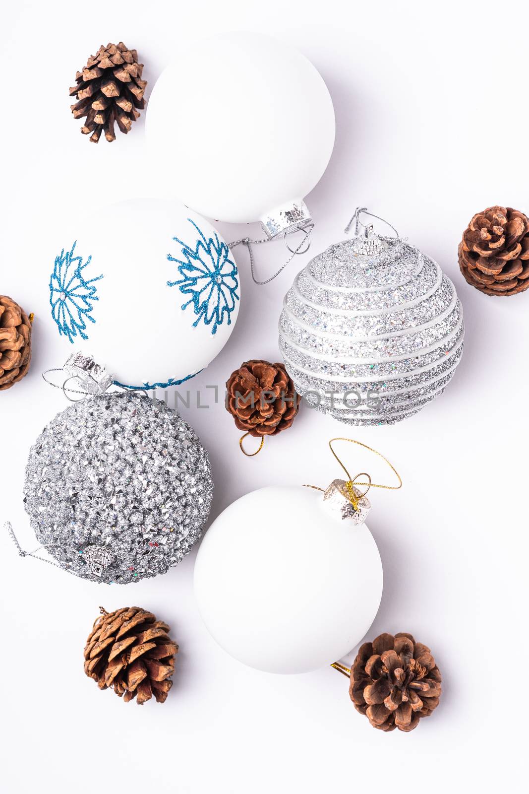 Christmas New Year composition. Gifts, fir tree cones, silver ball decorations on white background. Winter holidays concept. Flat lay, top view
