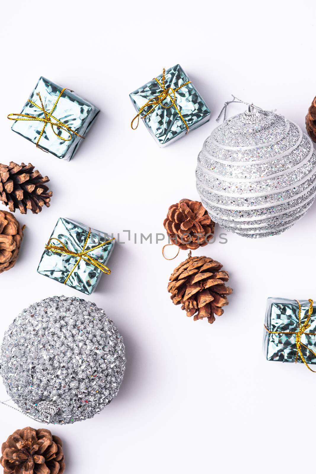 Christmas New Year composition. Gifts, fir tree cones, silver ball decorations on white background. Winter holidays concept. Flat lay, top view