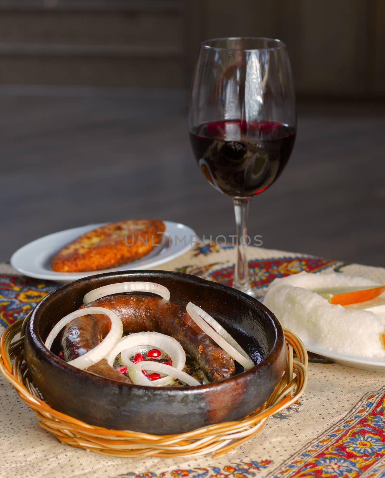 Georgian traditional food and cuisine Kupati and red wine, ghomi and cheese. On the table.