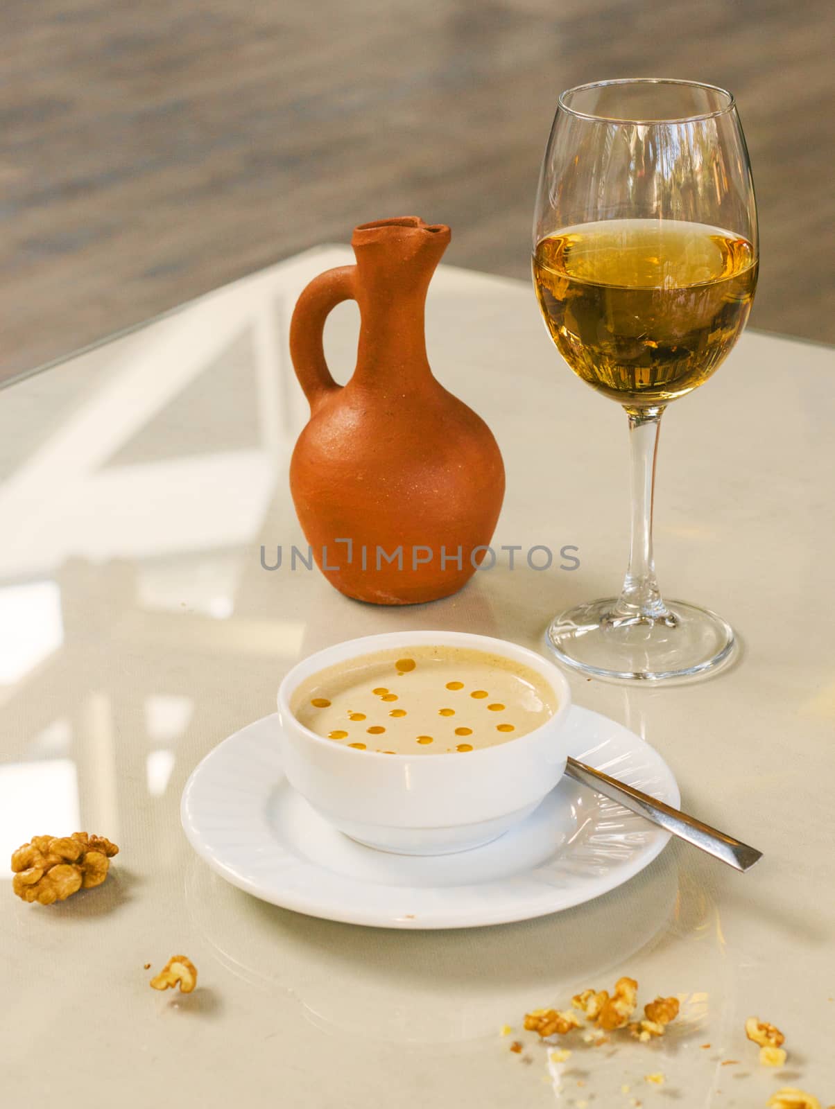 Walnut sauce in the bowl on the table with white wine, ready to eat. by Taidundua