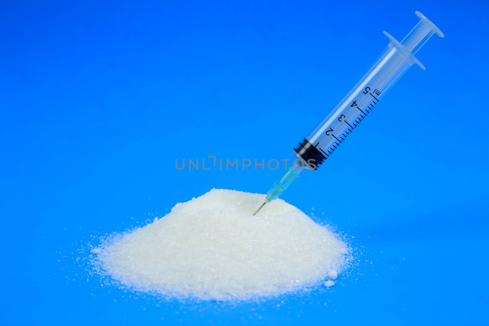 Conceptual photo of syringe and sugar emulating sugar addiction
