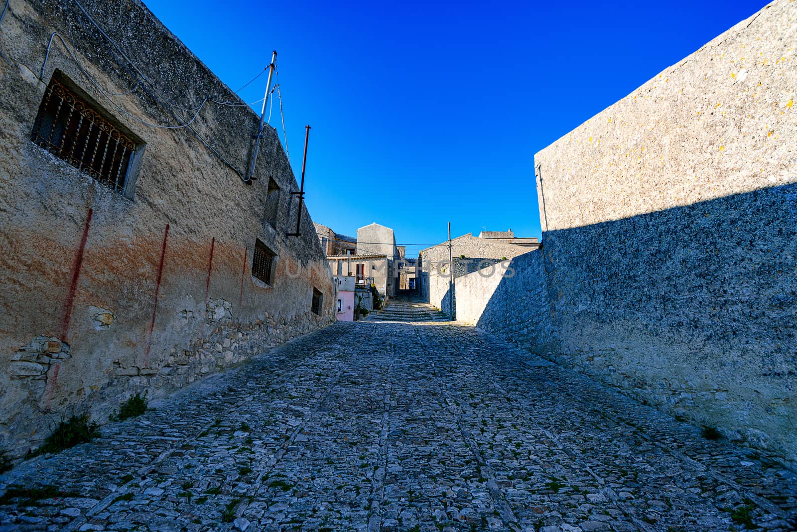cobblestone street in the ancient hill town of Erice by Nanisimova