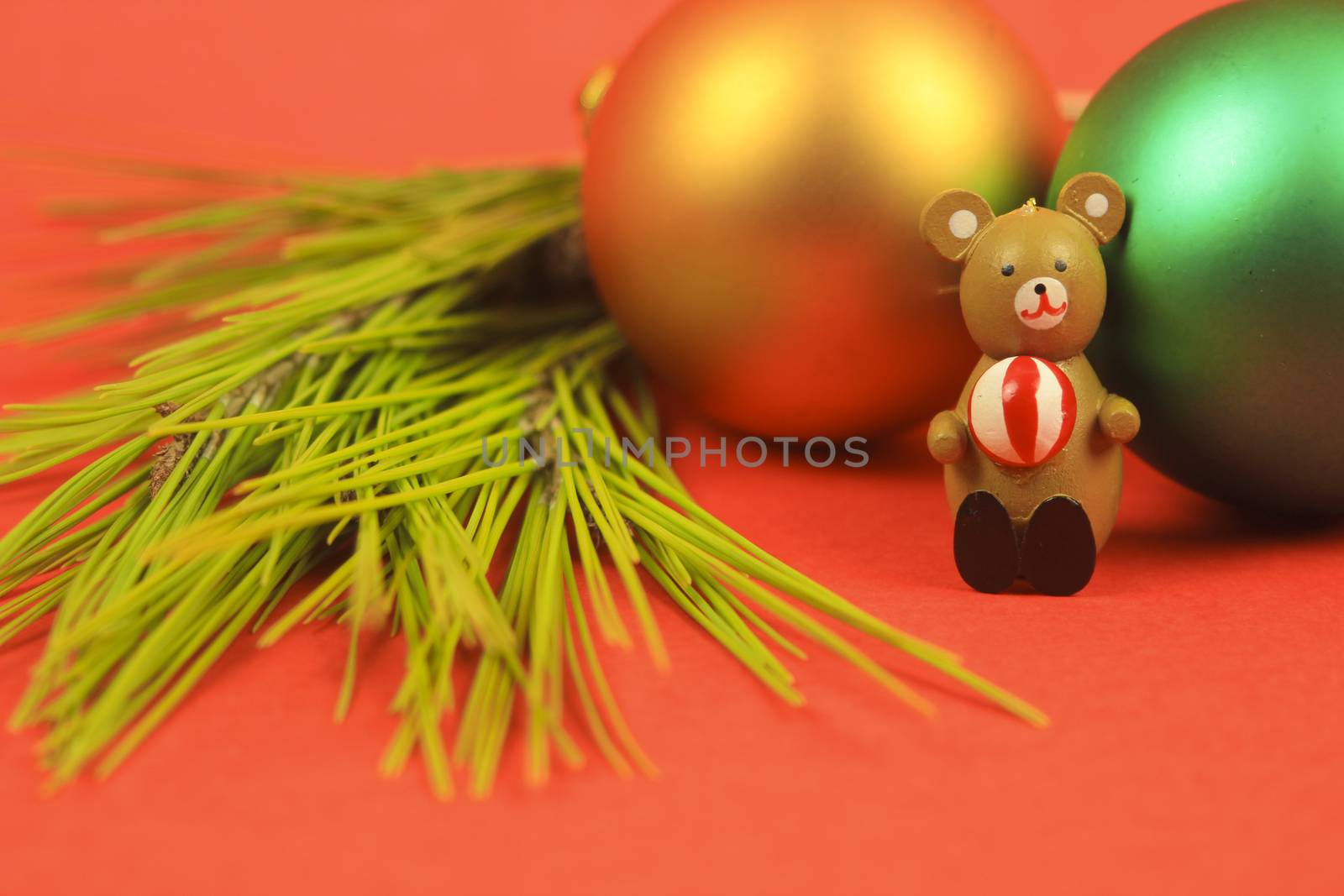 Wooden teddy bear with Christmas decoration on red background