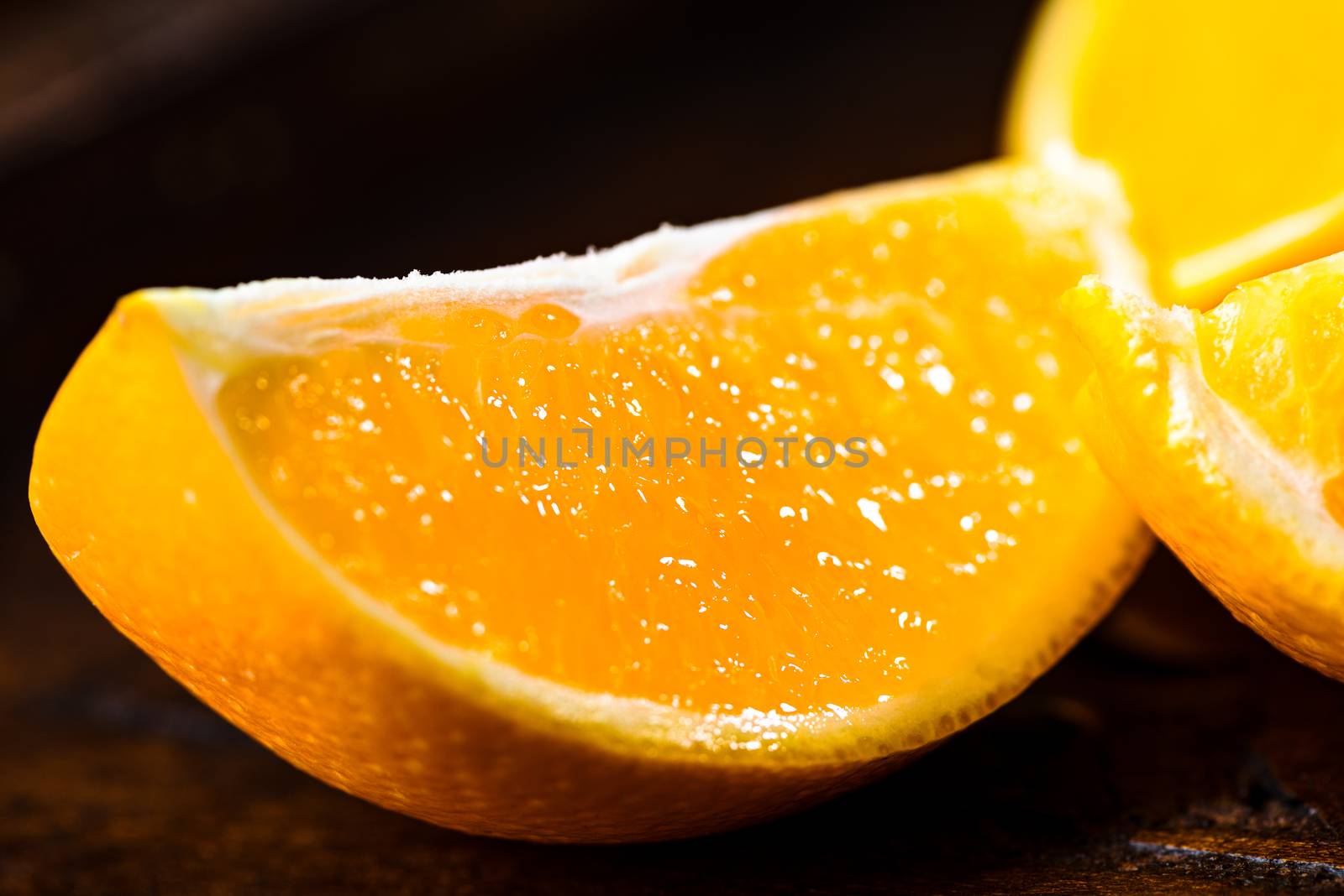 Sliced close up oranges on dark background with selective focus