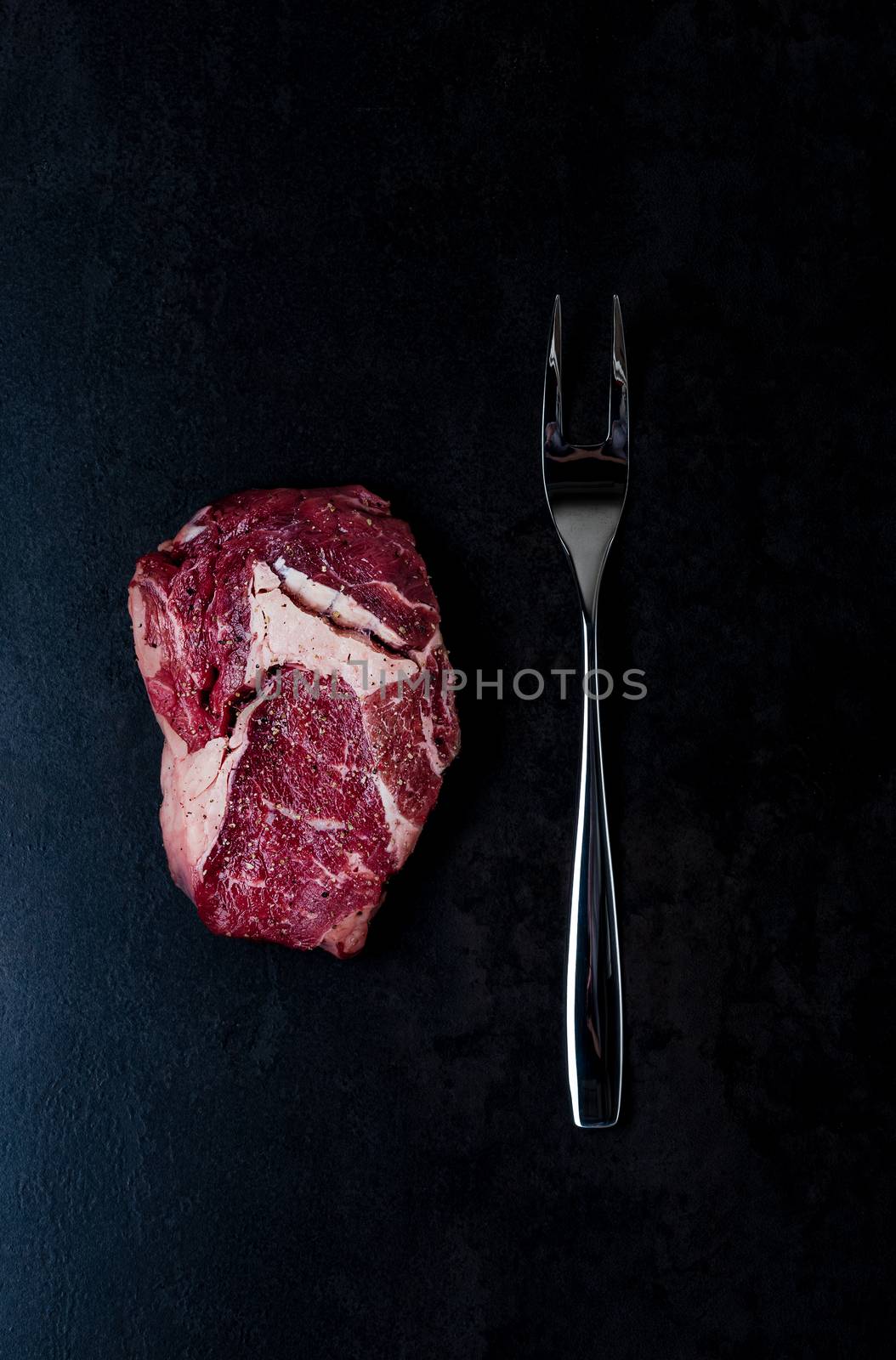 Top view on stone with steak and fork