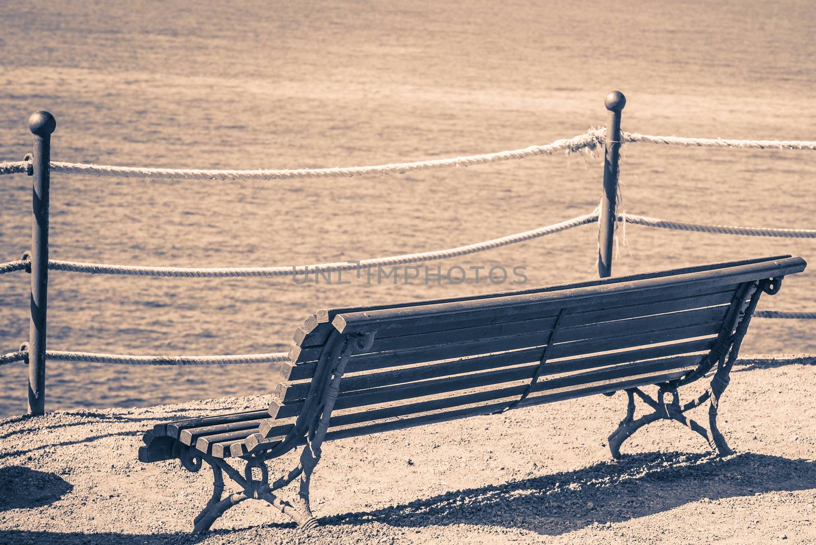Empty bench on the beach. Concept of loneliness, emptiness, solitude.