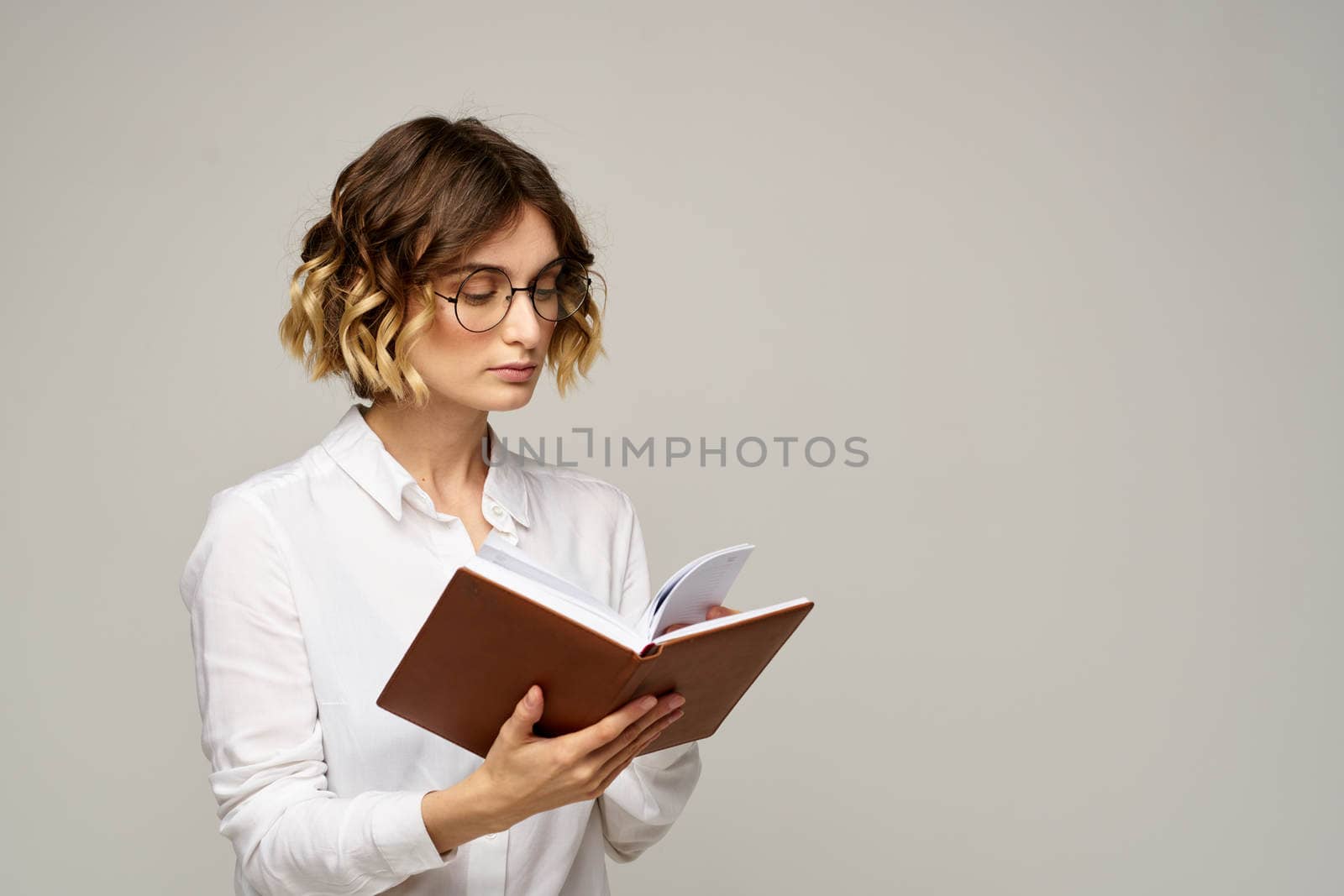woman with notepad in hands business work beige background glasses hairstyle. High quality photo
