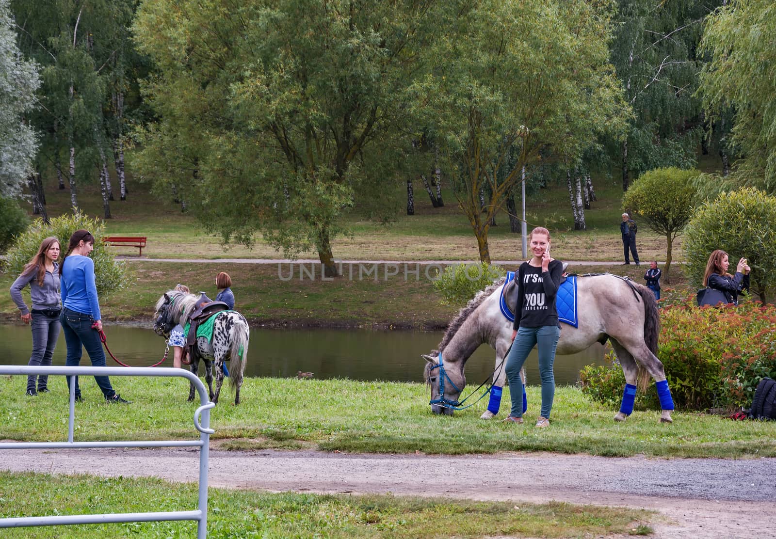 Near the river are girls and keep horses for the reins