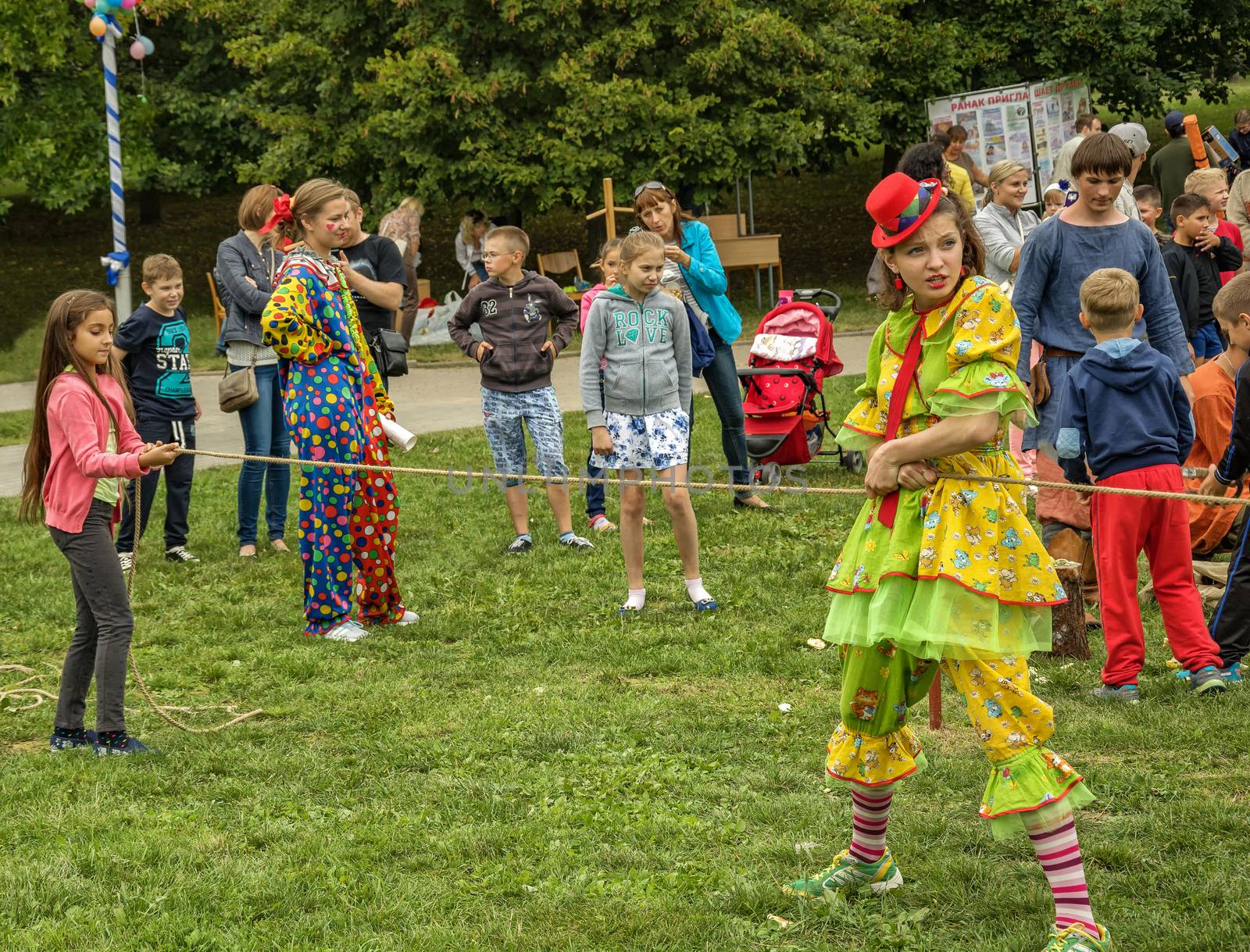 Children and dressed in clown costume a woman playing in the fresh air