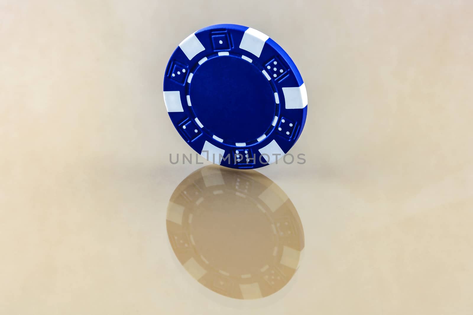 The blue casino chip stands on the reflecting surface by Grommik