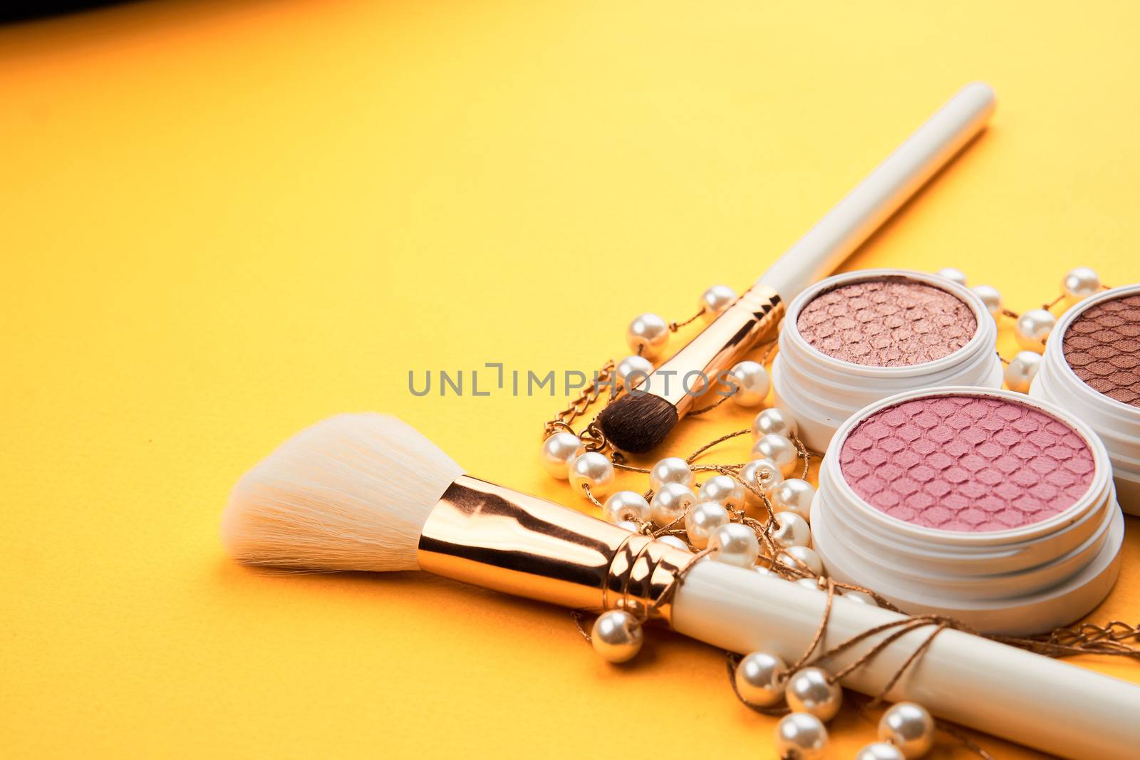 Eyeshadows on a yellow background professional cosmetics makeup brushes soft sponge fashion glasses by SHOTPRIME