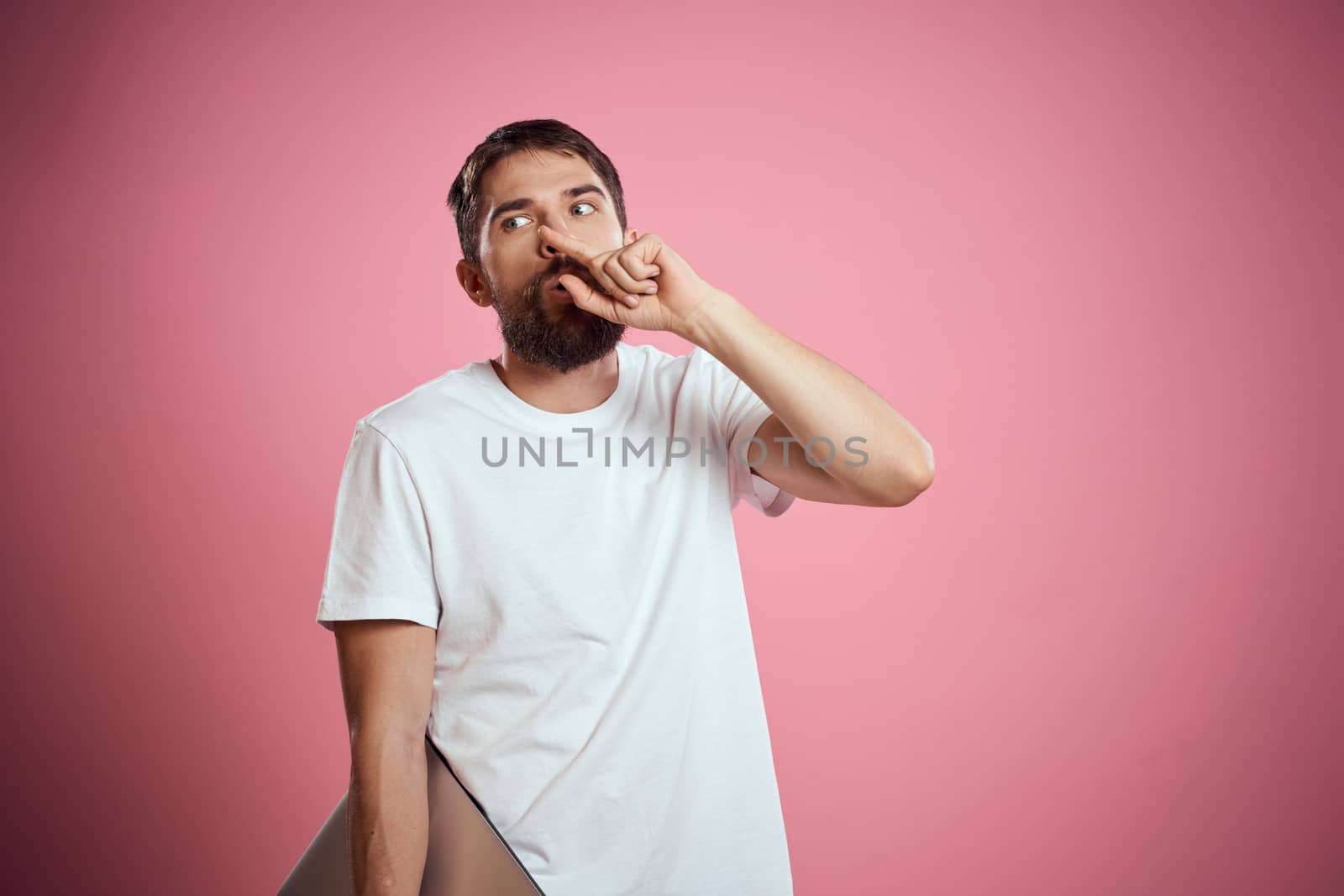emotional man with closed laptop in hands on pink background cropped view Copy Space by SHOTPRIME