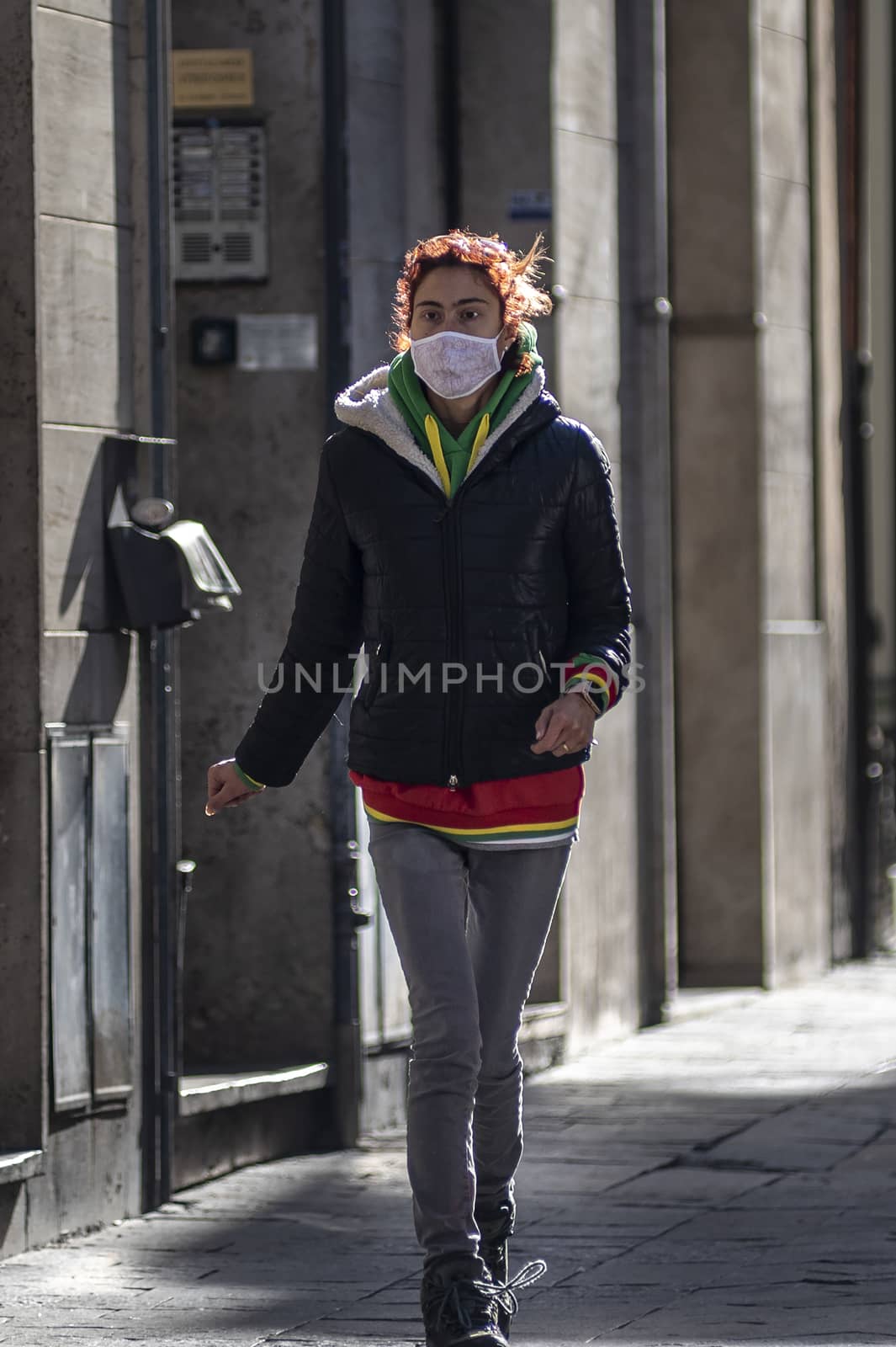 woman with medical mask walking downtown by carfedeph