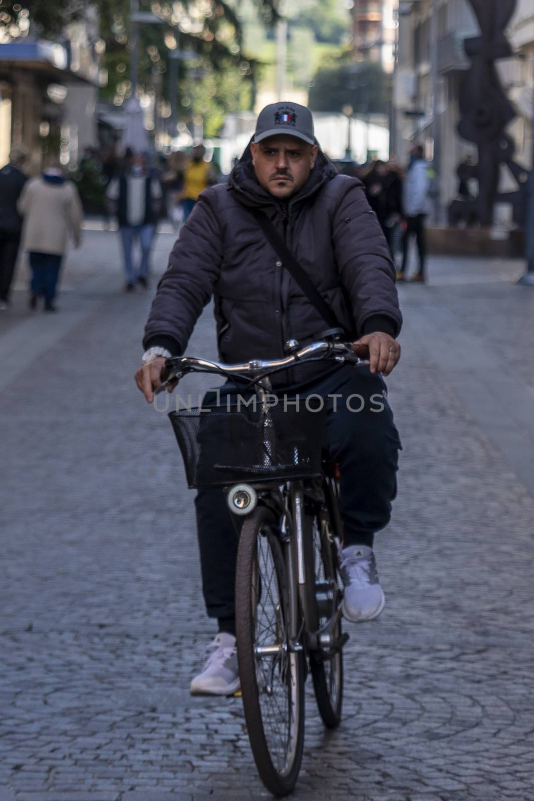 man on bicycle in city center by carfedeph