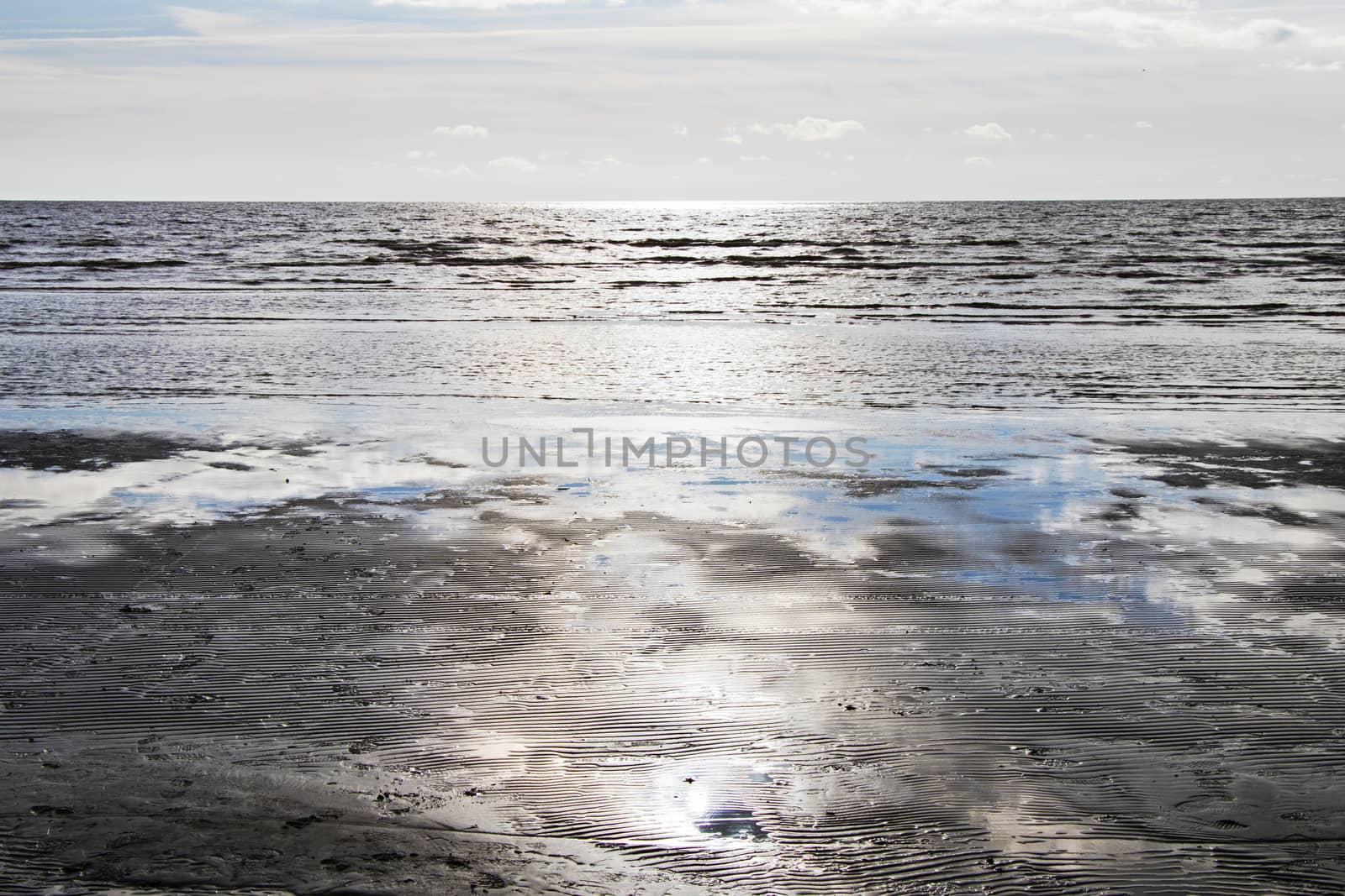 Seascape of sea water and beach, sand and clouds , horizon in Estonia.