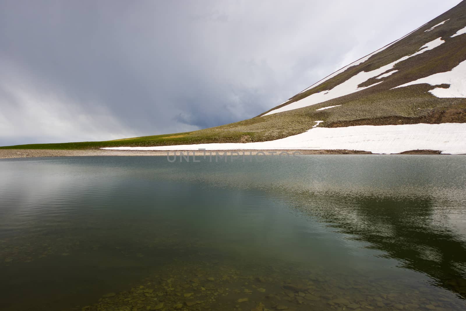 Alpine mountain lake landscape and view, snow and clouds in Javakheti, Georgia