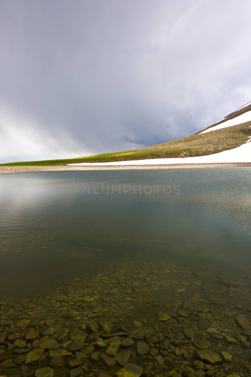 Alpine mountain lake landscape at the daytime, colorful landscape, snow and clouds by Taidundua