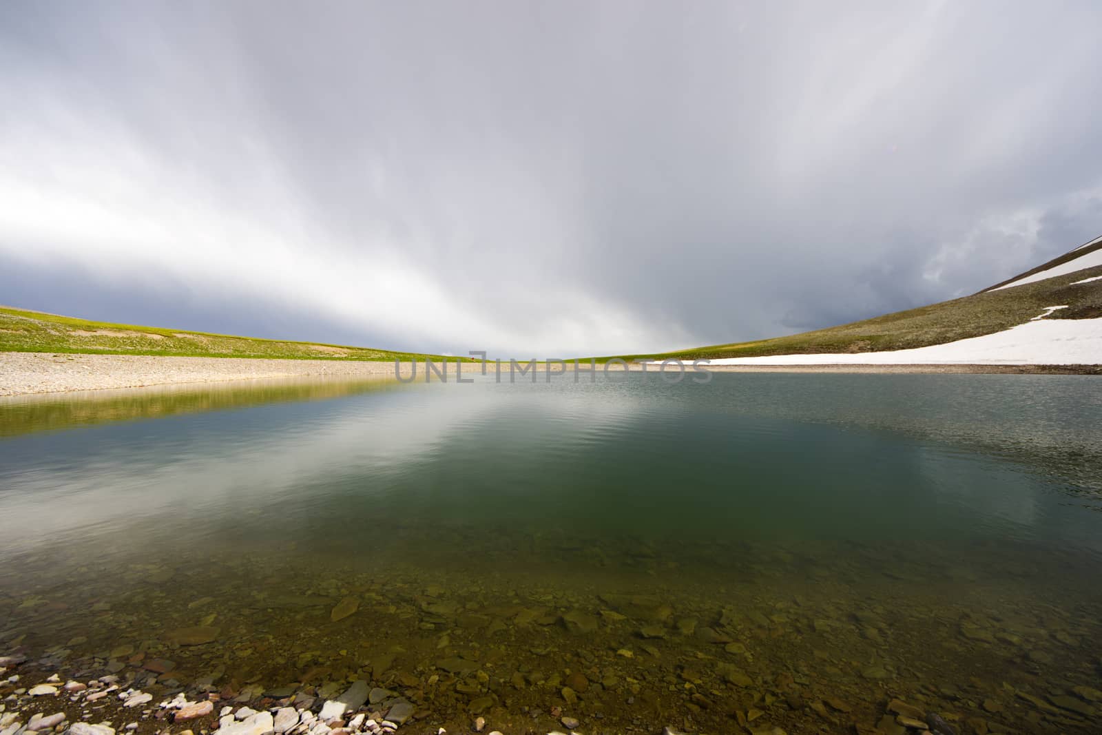 Alpine mountain lake landscape and view, snow and clouds in Javakheti, Georgia