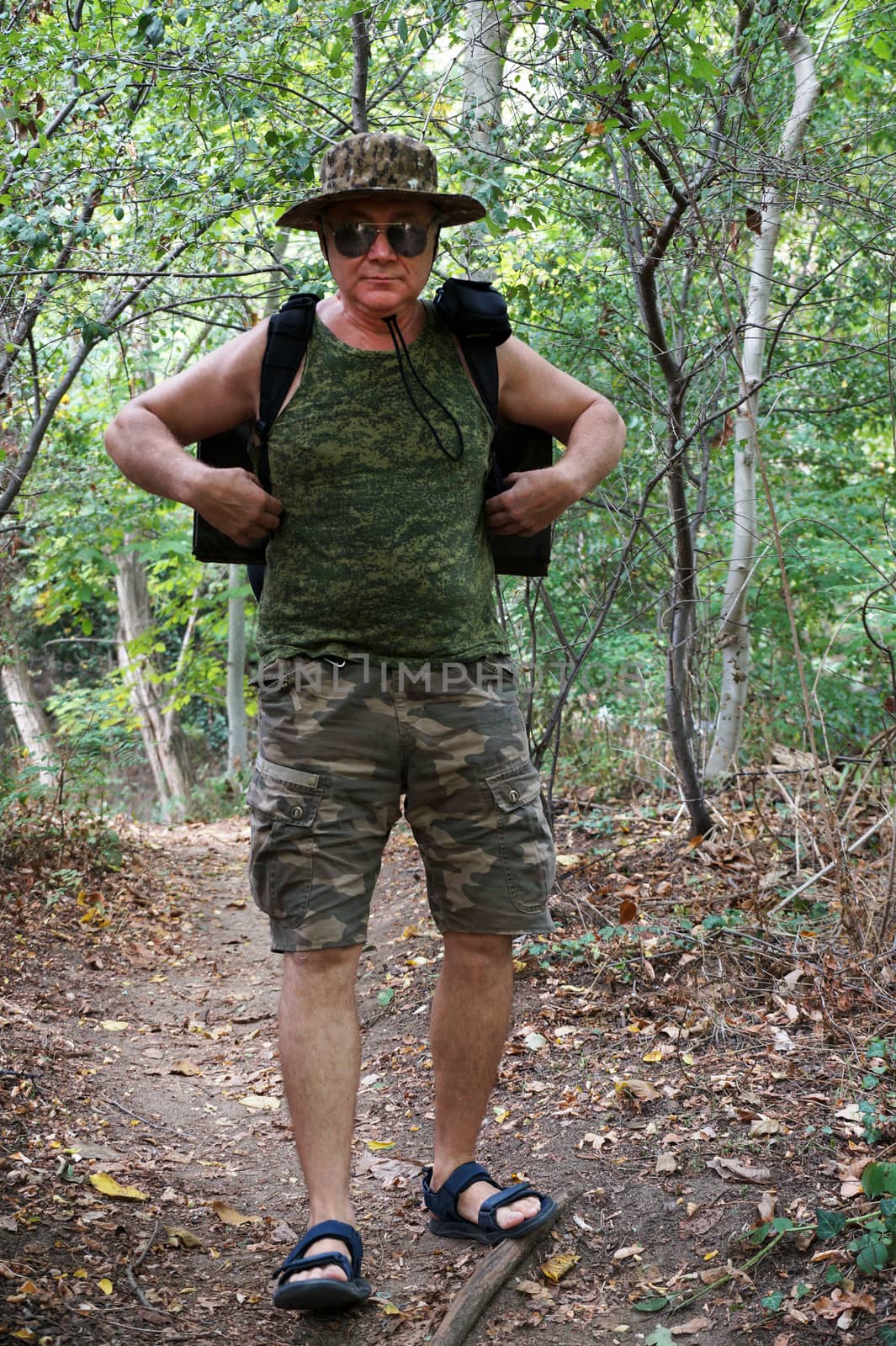 a man with a backpack walks along a path in the forest.